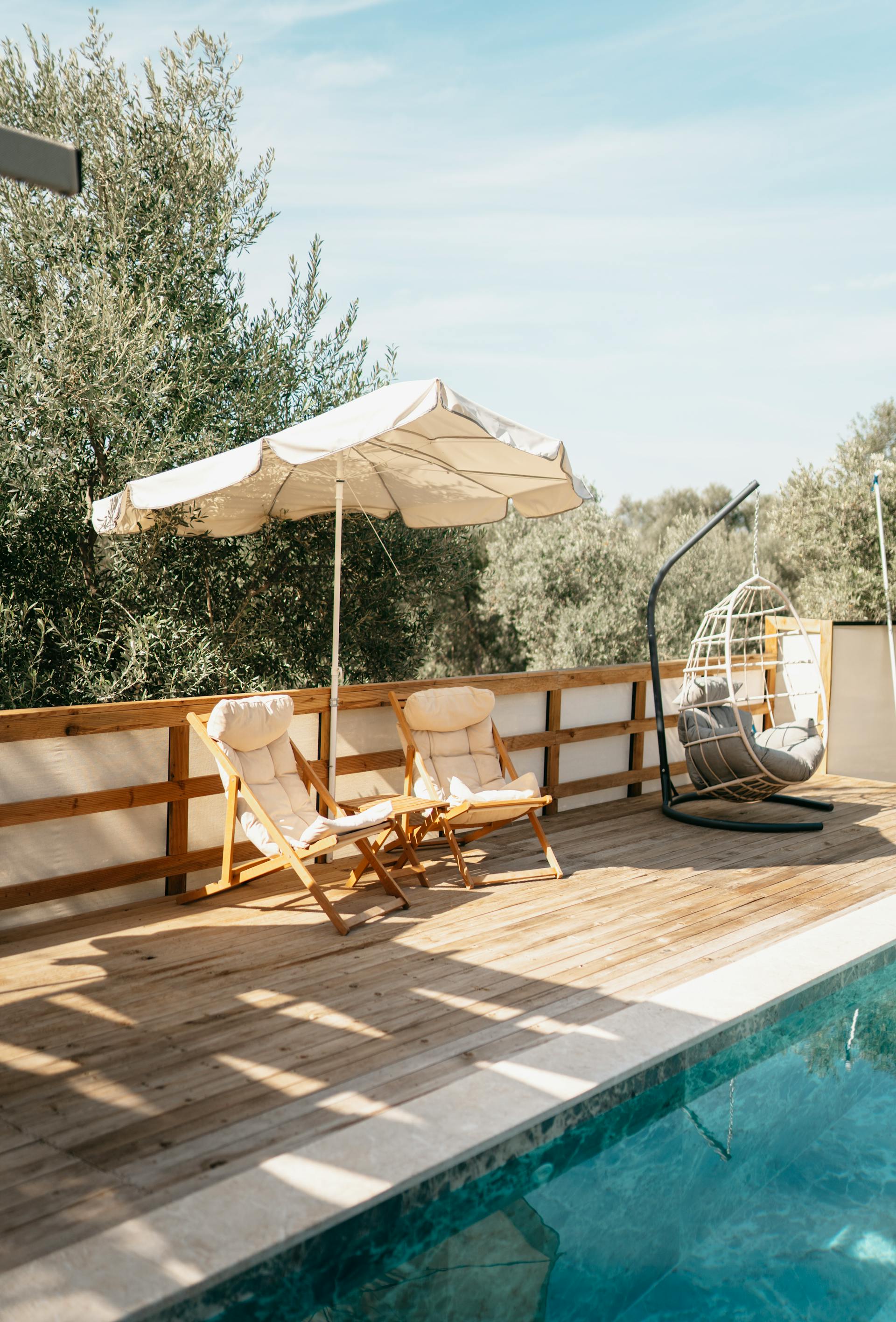 Un parasol et des chaises longues placés près d'une piscine | Source : Pexels