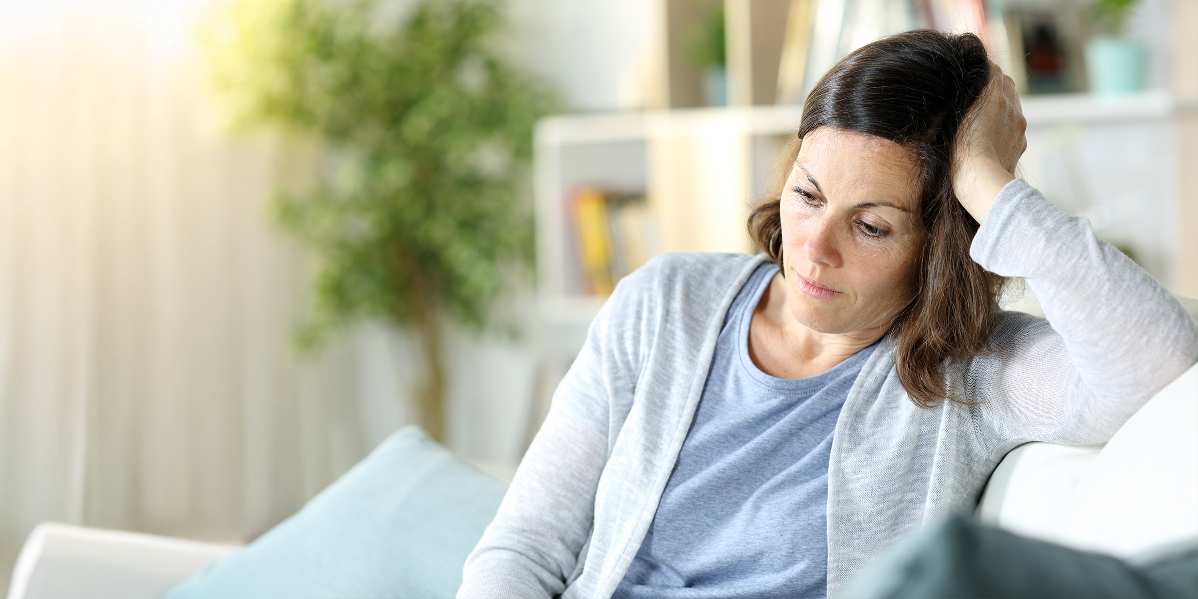 Une femme triste et pensive dans un salon | Source : Shutterstock