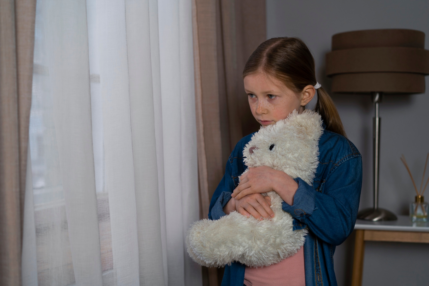 Une jeune fille triste tenant un ours en peluche | Source : Freepik