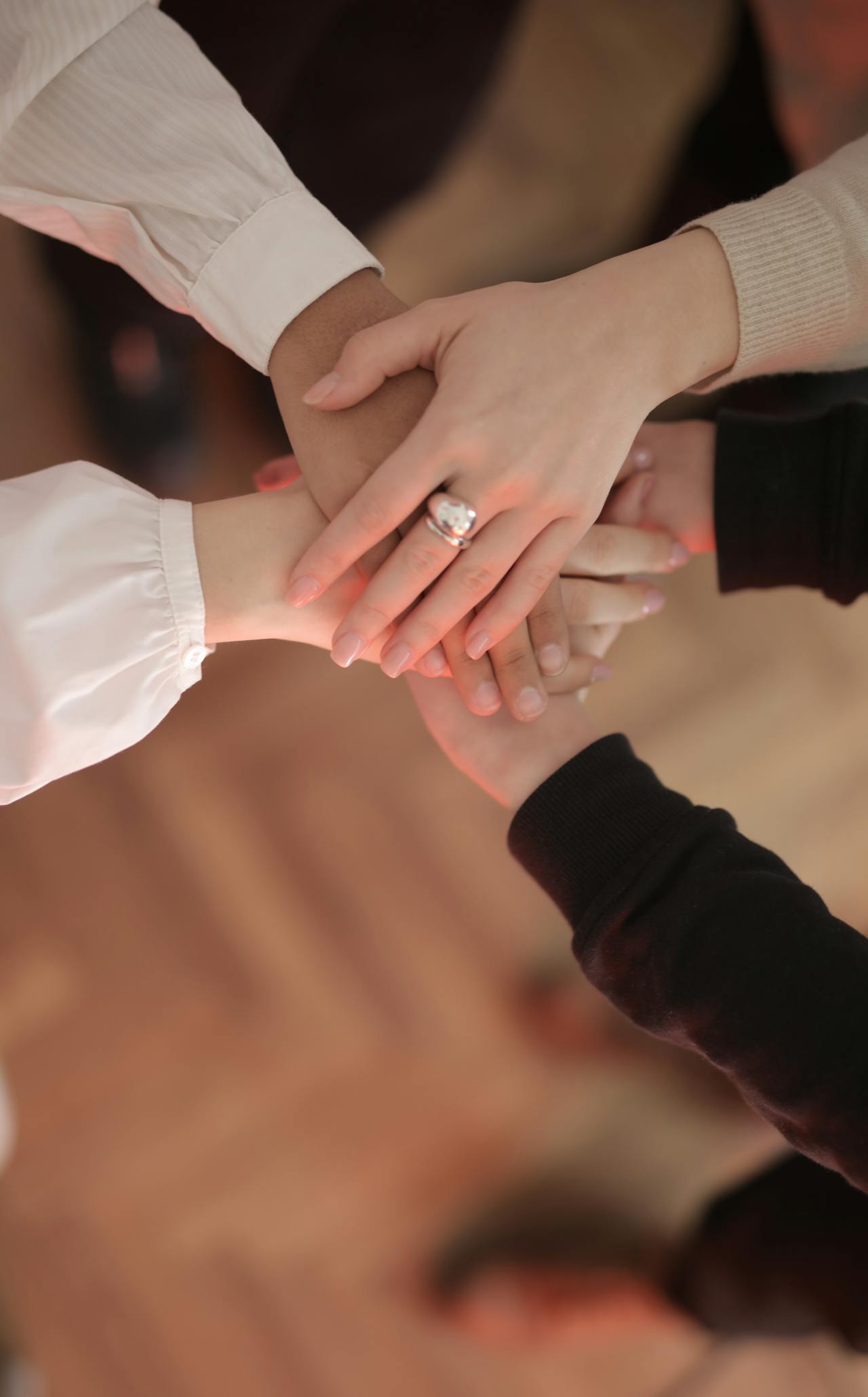 Un groupe d'amis empilant leurs mains ensemble | Source : Pexels