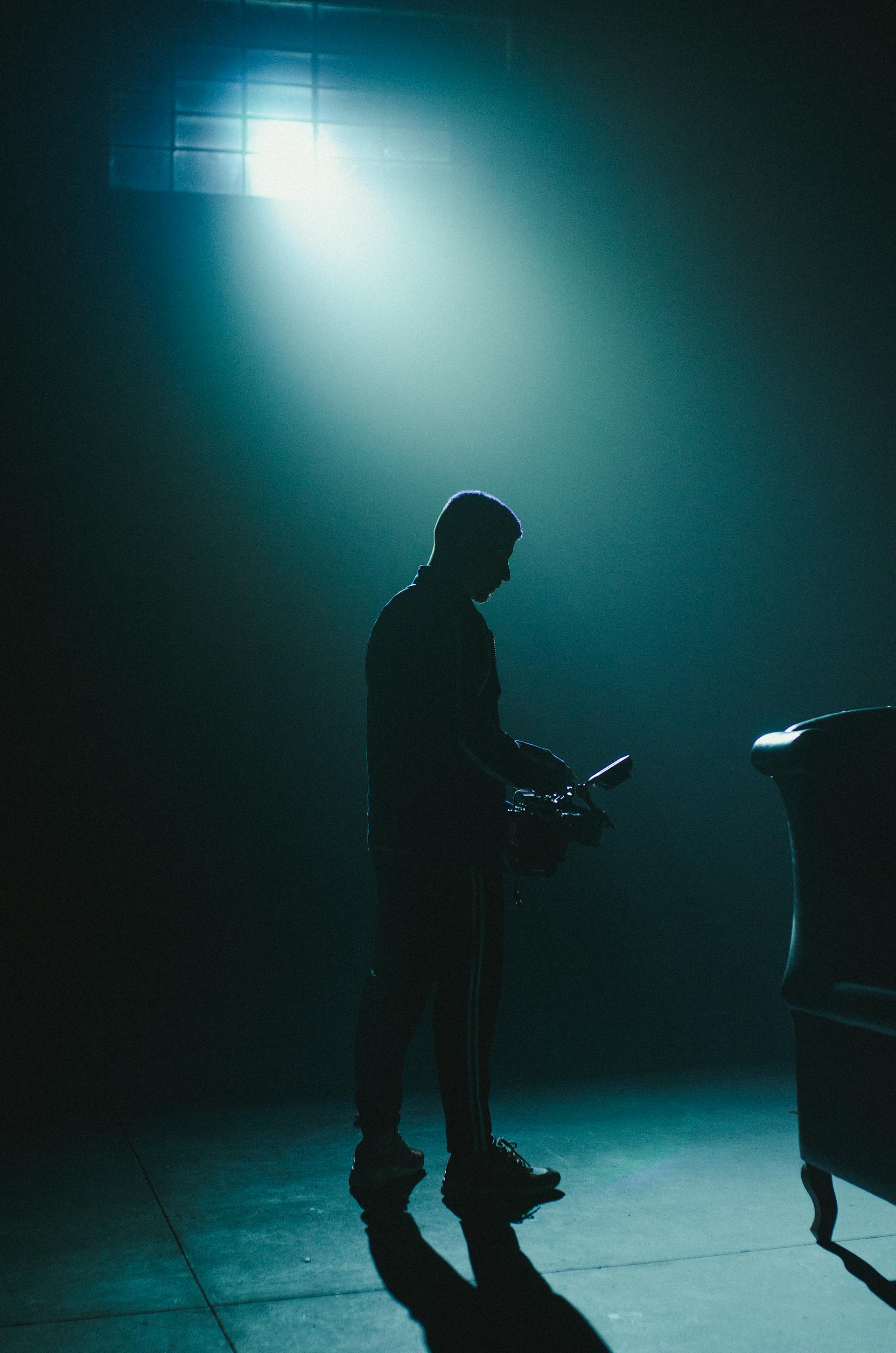 La silhouette d'un homme debout dans une pièce sombre | Source : Pexels