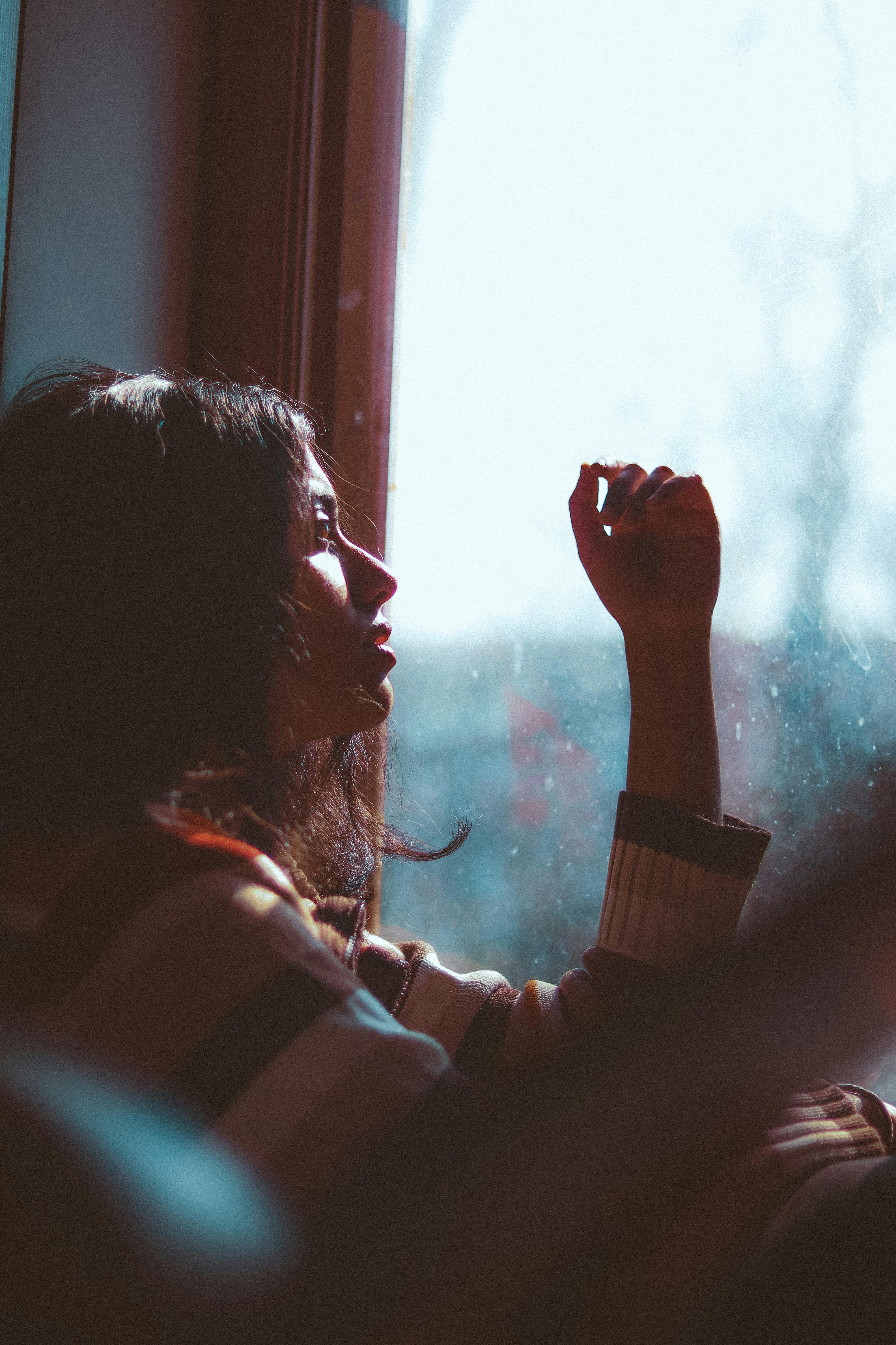 Femme assise près d'une fenêtre | Source : Pexels
