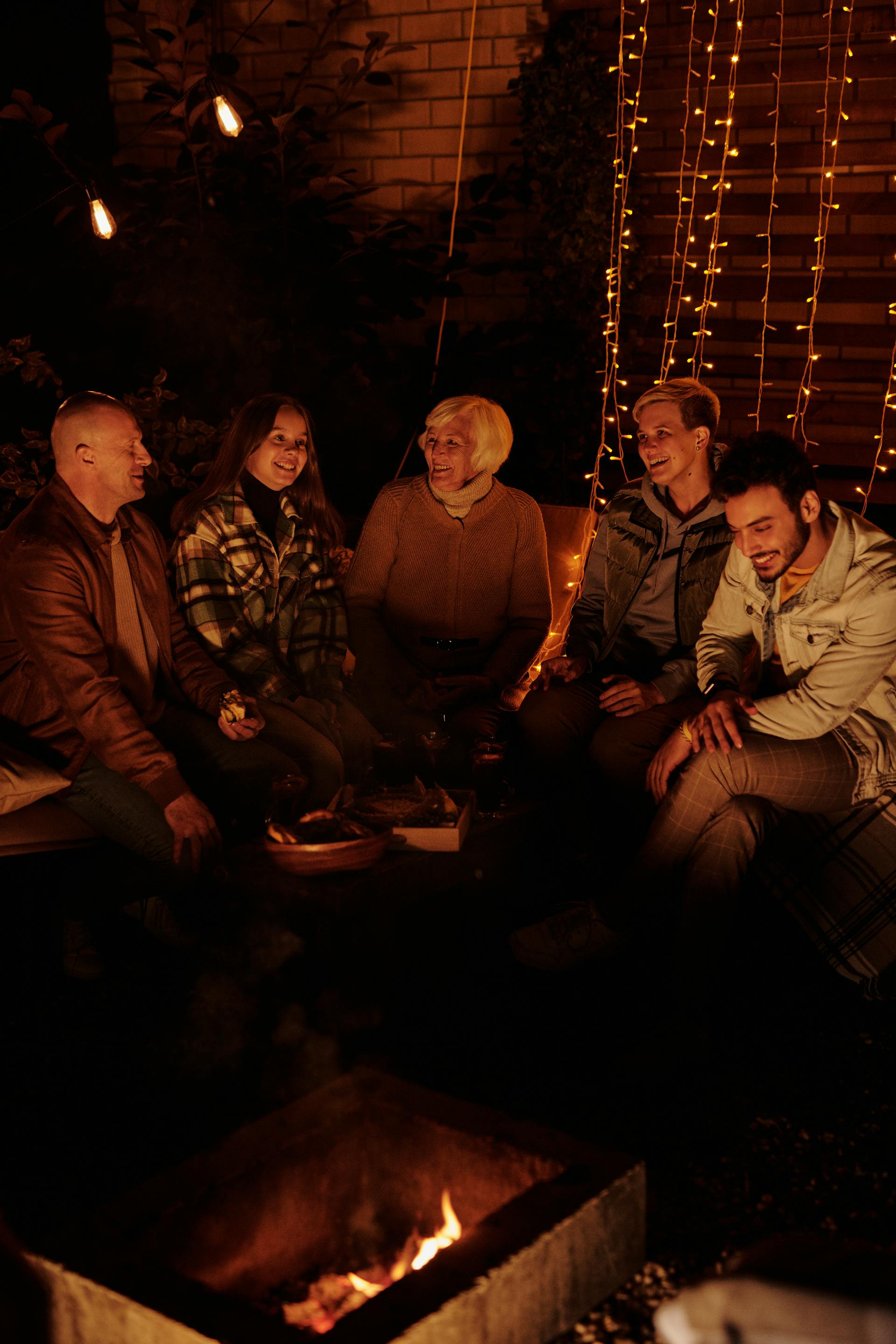 Une famille se réunissant autour d'un feu de joie la nuit | Source : Pexels