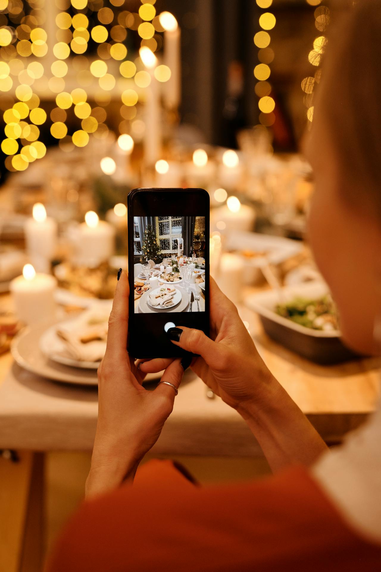 Une femme prenant une photo de la nourriture sur la table | Source : Pexels