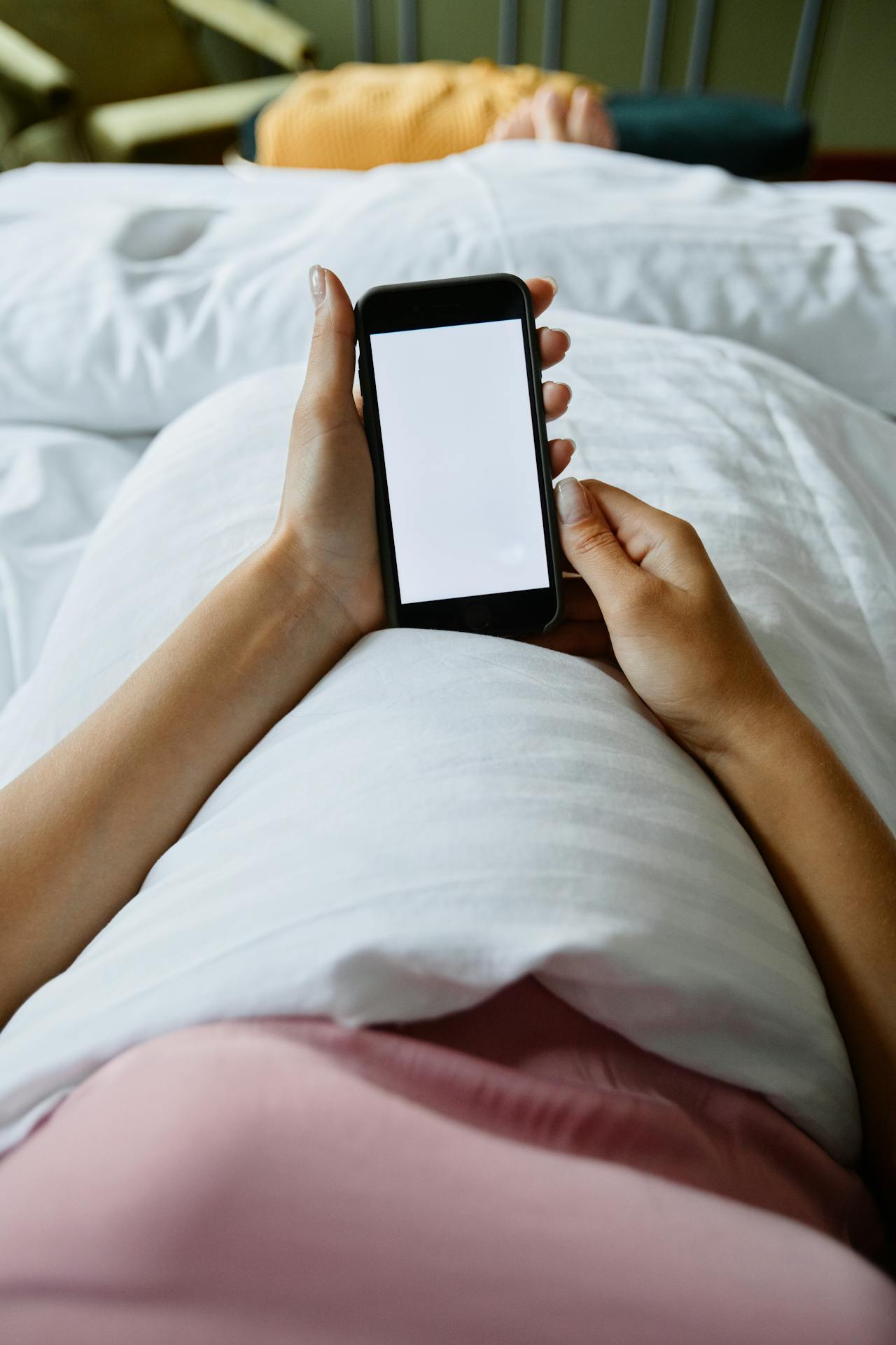 Une femme utilisant son téléphone au lit | Source : Pexels