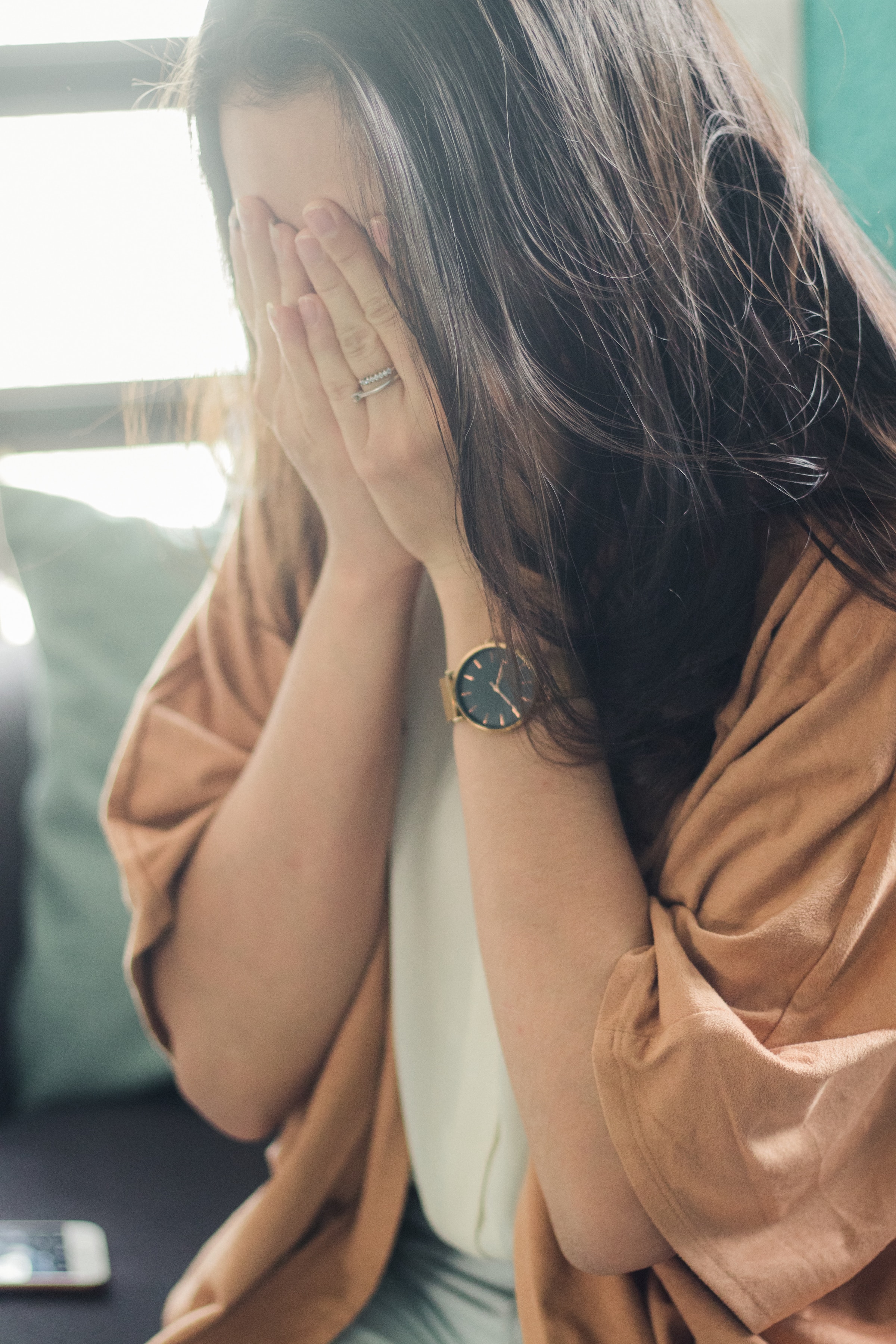 Une jeune femme se couvrant le visage avec ses mains | Source : Unsplash