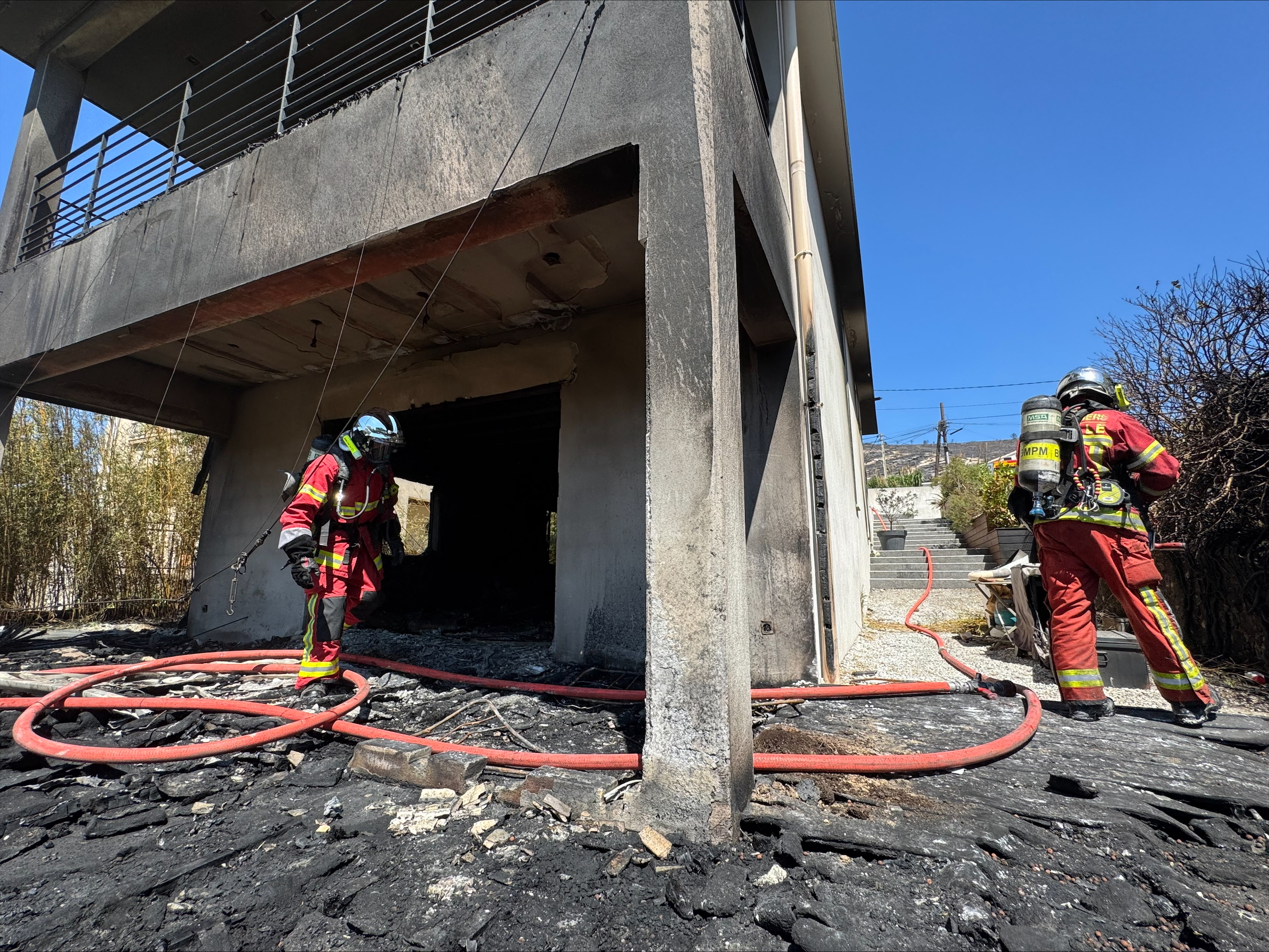 Des pompiers français inspectent une propriété incendiée dans le quartier de Pelouque à Marseille, dans le sud de la France, le 9 juillet 2025, après qu'un incendie a ravagé des zones proches du centre de la ville I Source : Getty Images