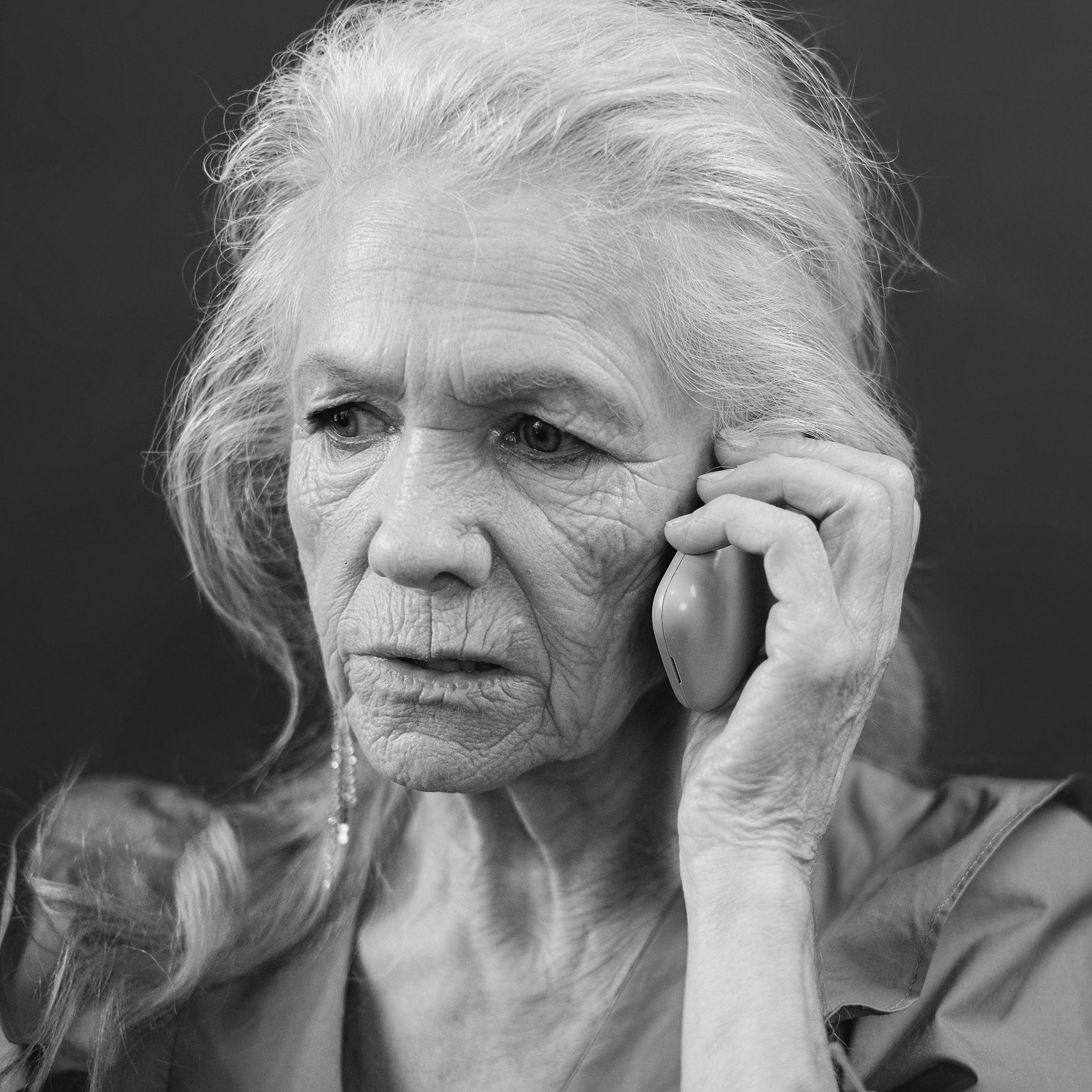 Une femme âgée inquiet lors d'un appel téléphonique | Source : Midjourney