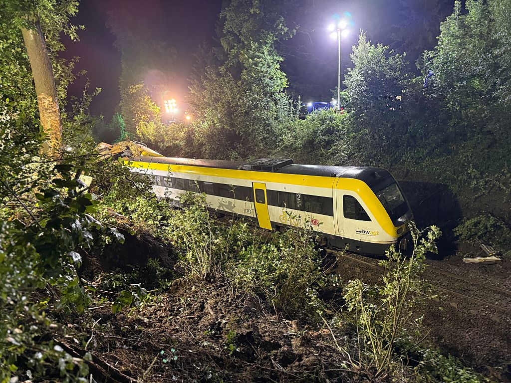 Un wagon du train de voyageurs déraillé est immobilisé sur une section de voie. | Source : Getty Images