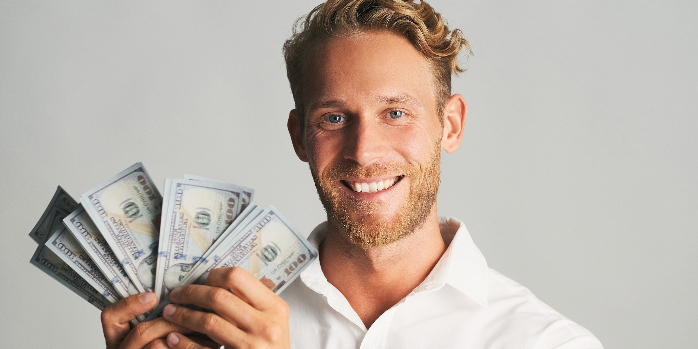 Un homme tenant des billets de banque | Source : Freepik
