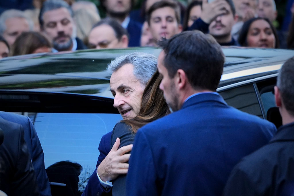 L'ancien président français Nicolas Sarkozy embrasse sa femme Carla Bruni Sarkozy avant de monter dans la voiture qui le conduira à la Prison de la Sante, où il devra purger une peine de cinq ans, le 21 octobre 2025 à Paris. | Source : Getty Images