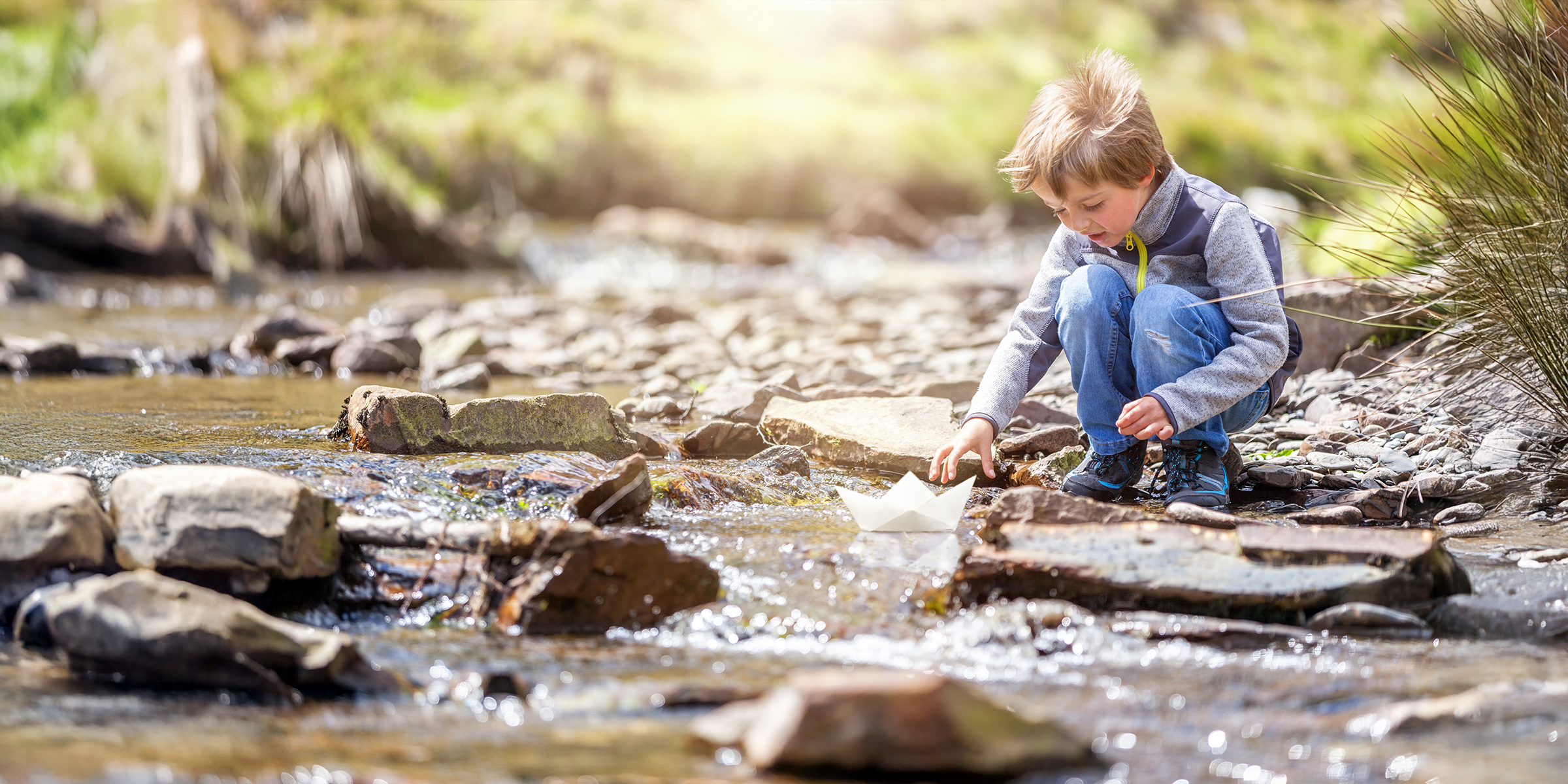 Un enfant jouant dans un ruisseau | Source : Shutterstock