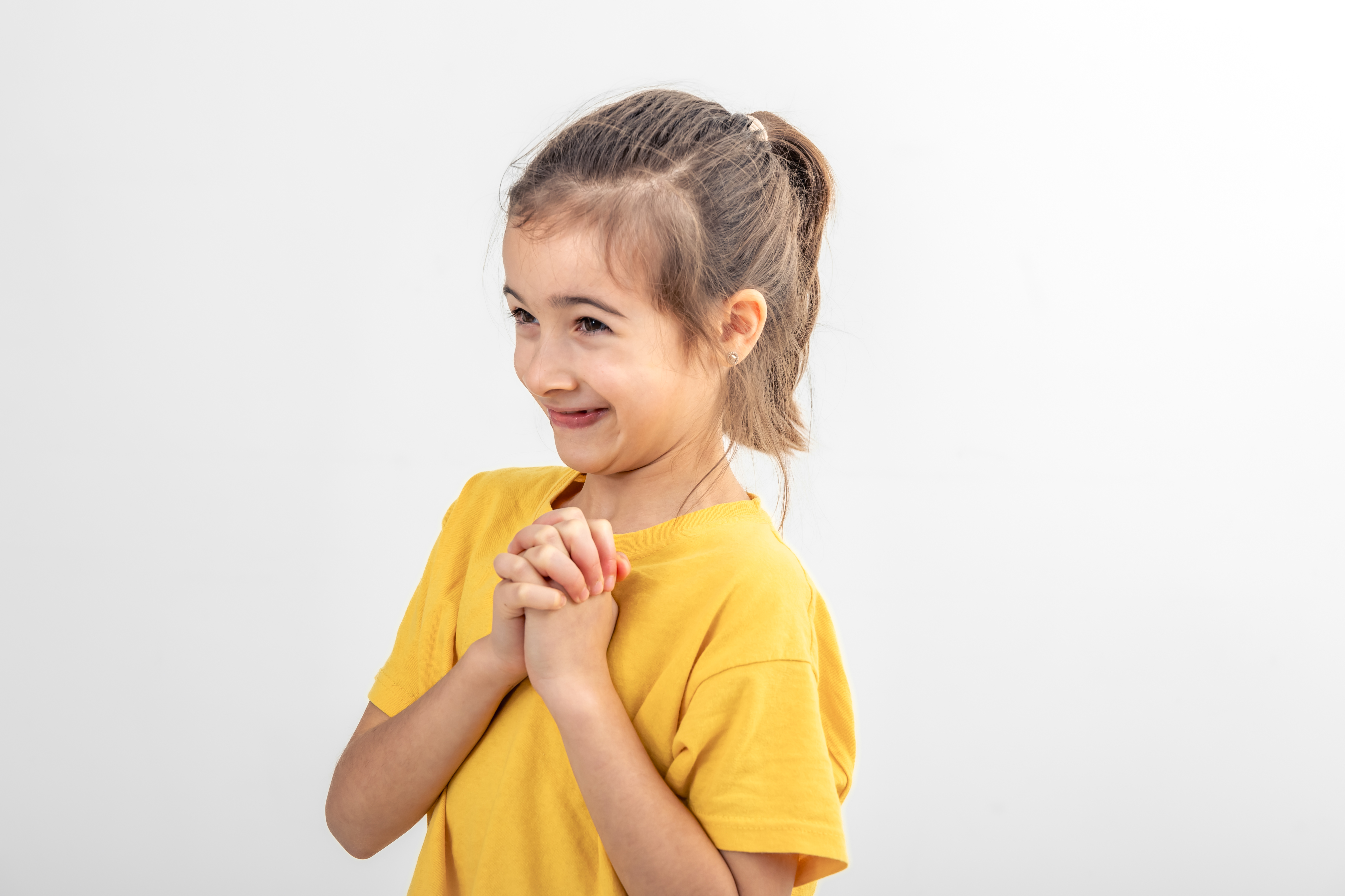 Une fille heureuse qui serre ses mains | Source : Freepik