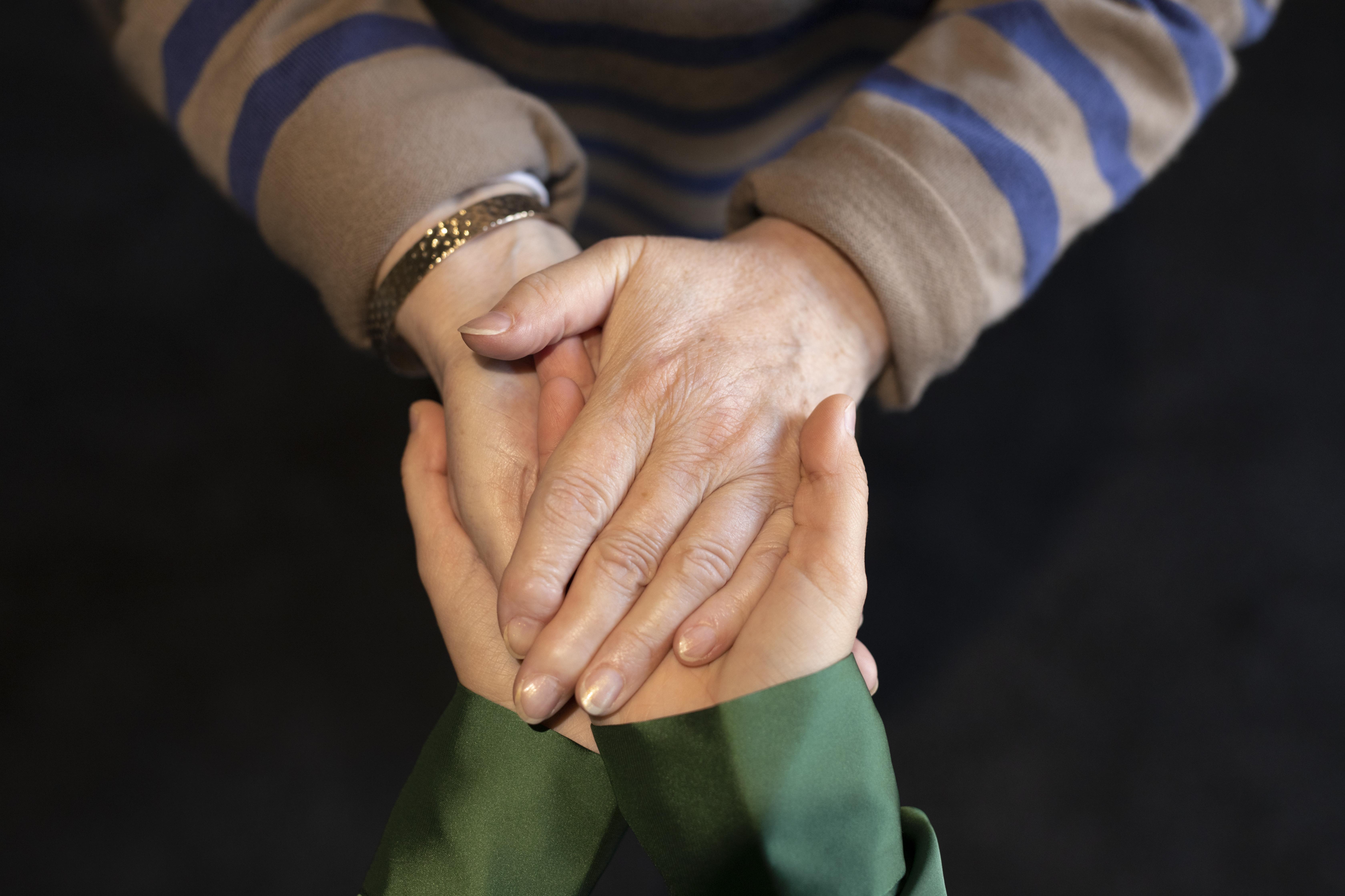 Une jeune femme et une dame plus âgée se tiennent par la main | Source : Freepik