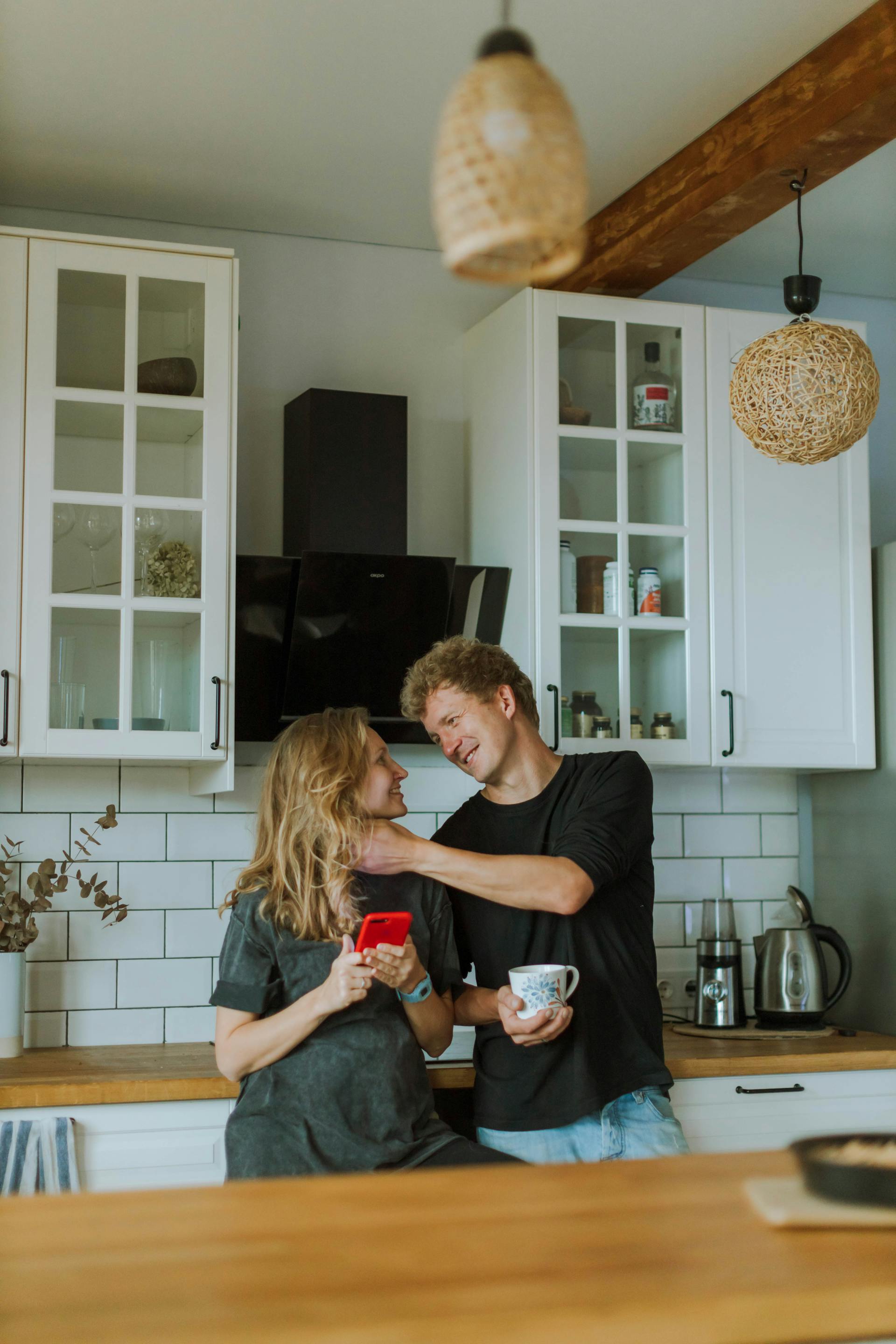 Un couple partageant un doux moment dans la cuisine | Source : Pexels