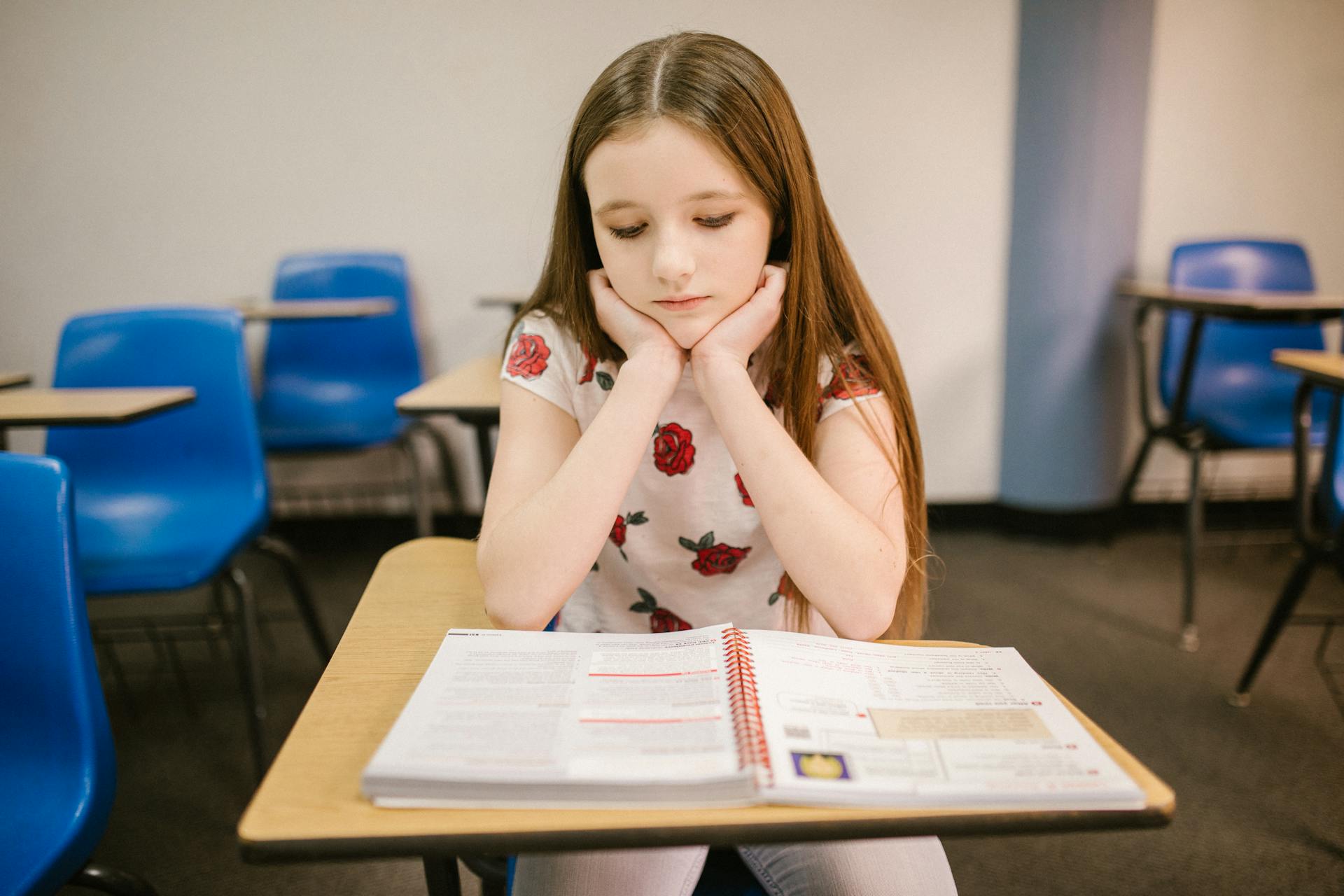 Une petite fille triste assise dans sa salle de classe | Source : Pexels