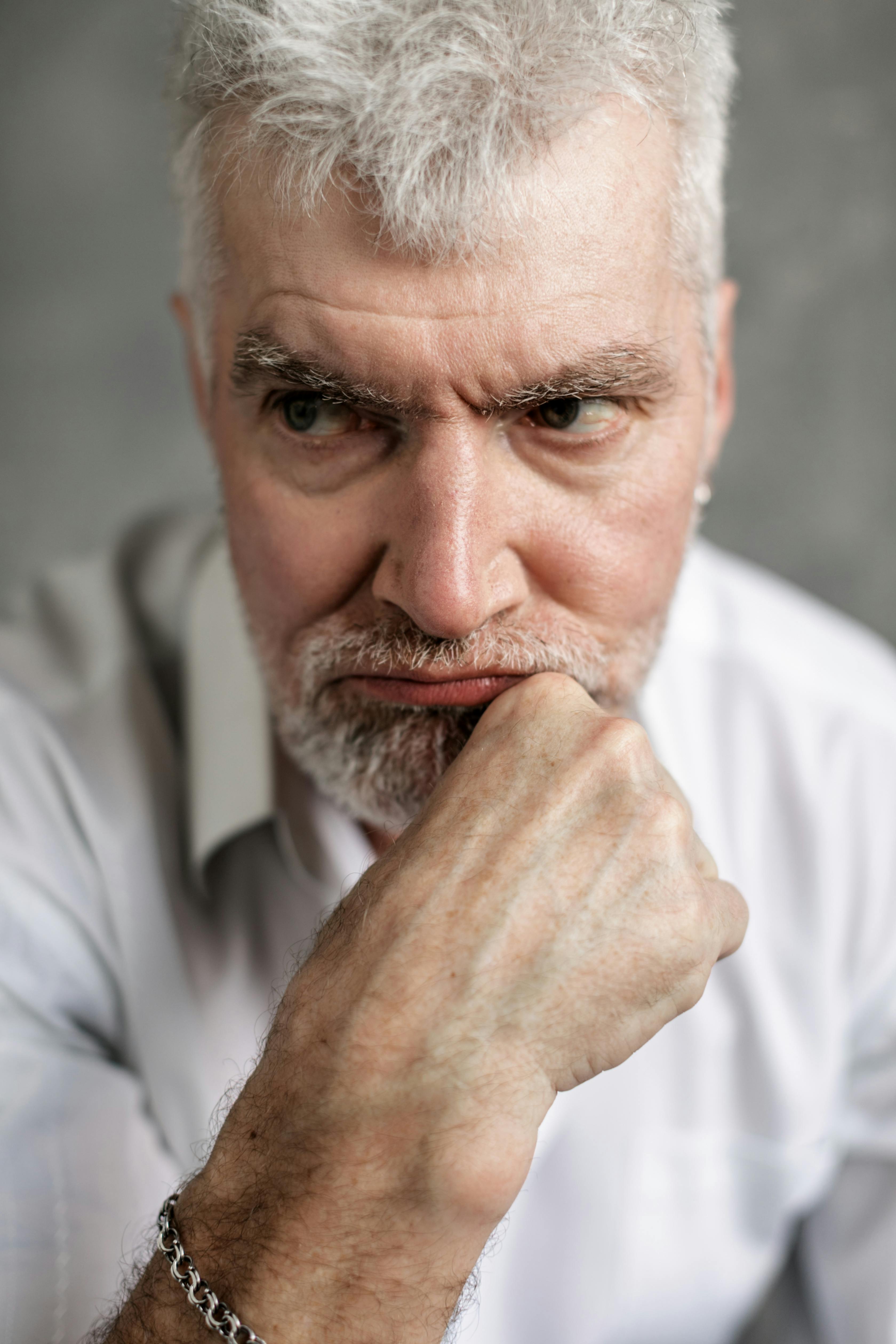Un homme grincheux, le menton posé sur sa main | Source : Pexels
