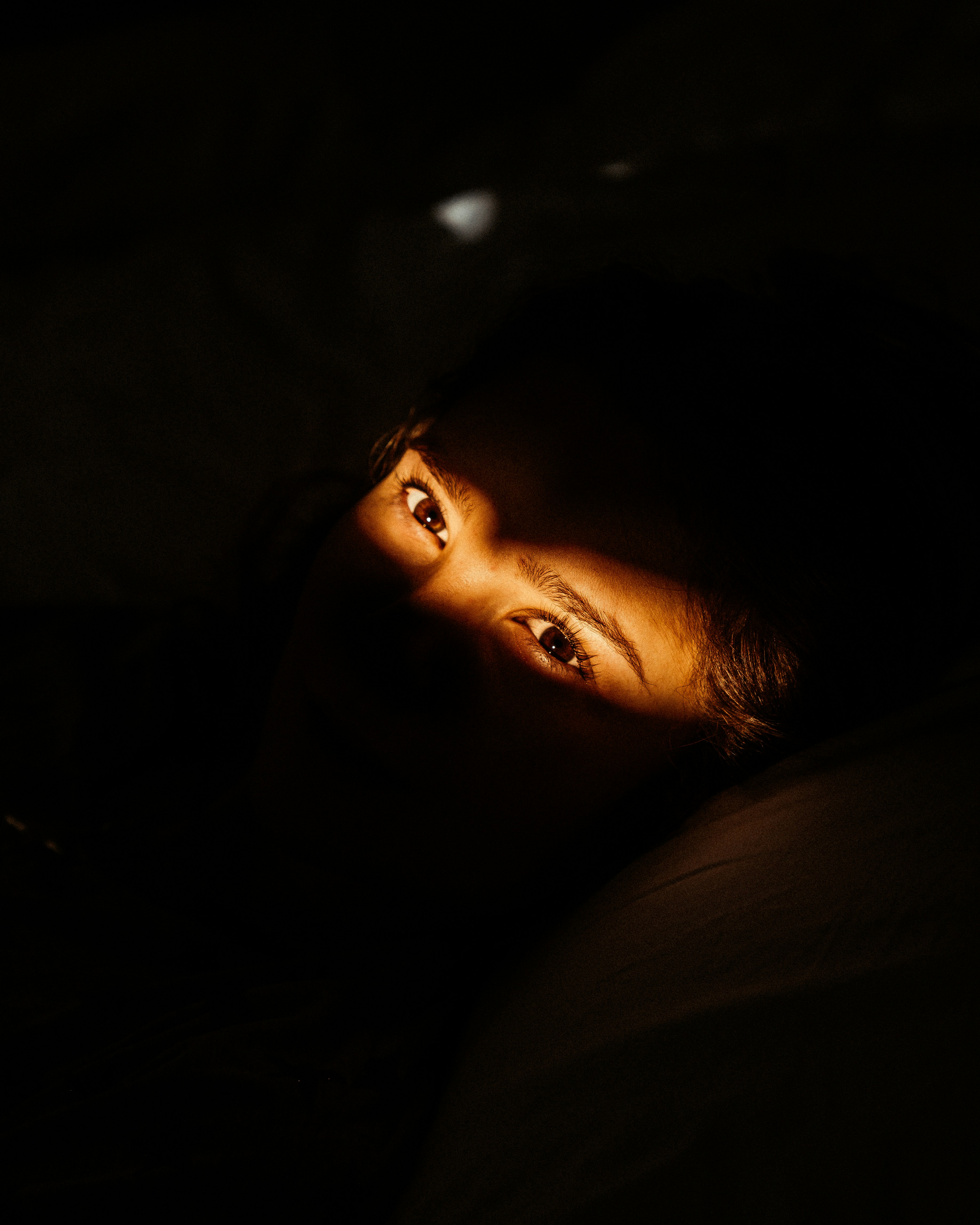 Vue des yeux d'un homme éveillé dans son lit | Source : Unsplash