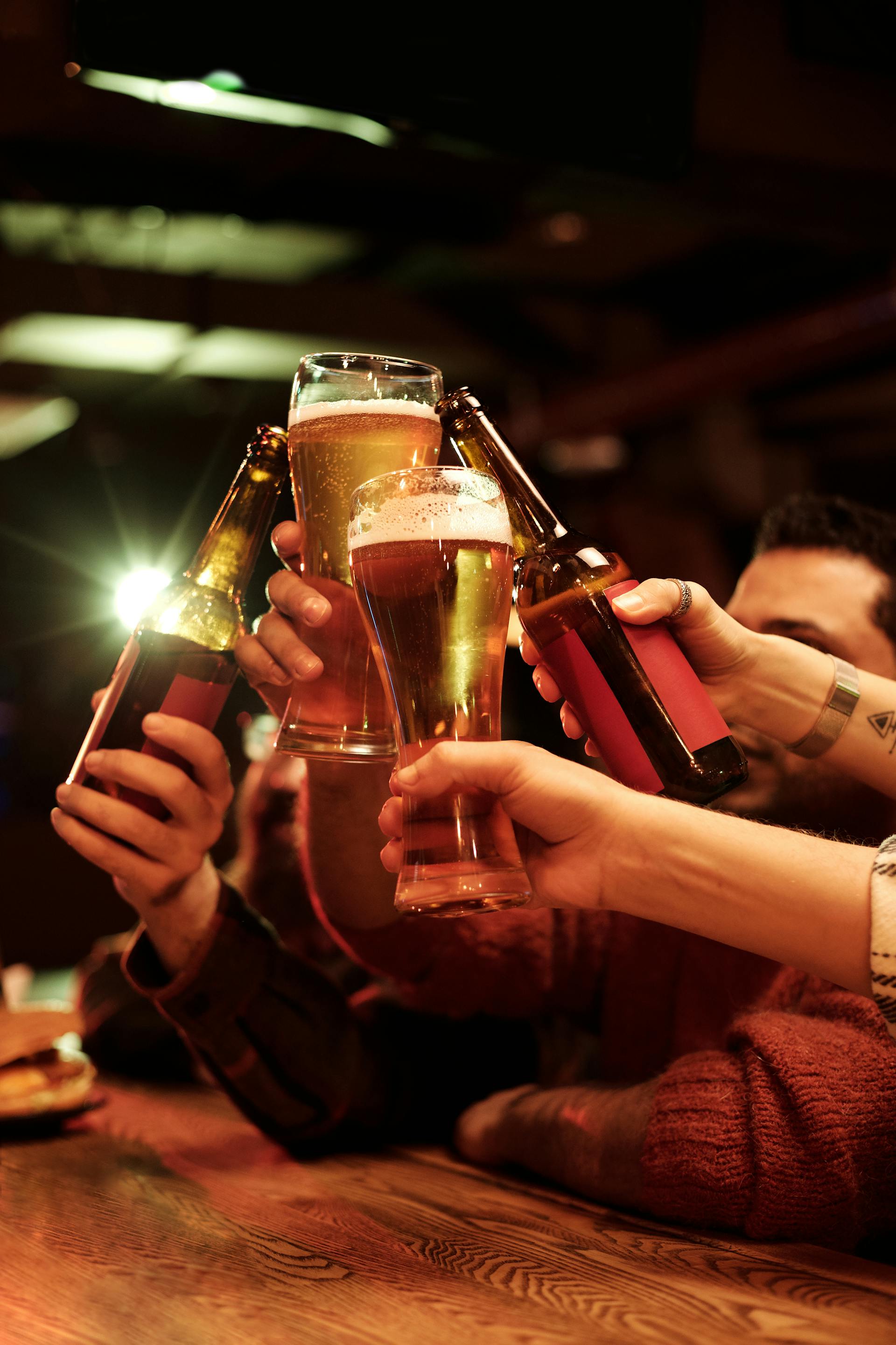 Un groupe d'hommes faisant tinter leurs verres de bière ensemble | Source : Pexels