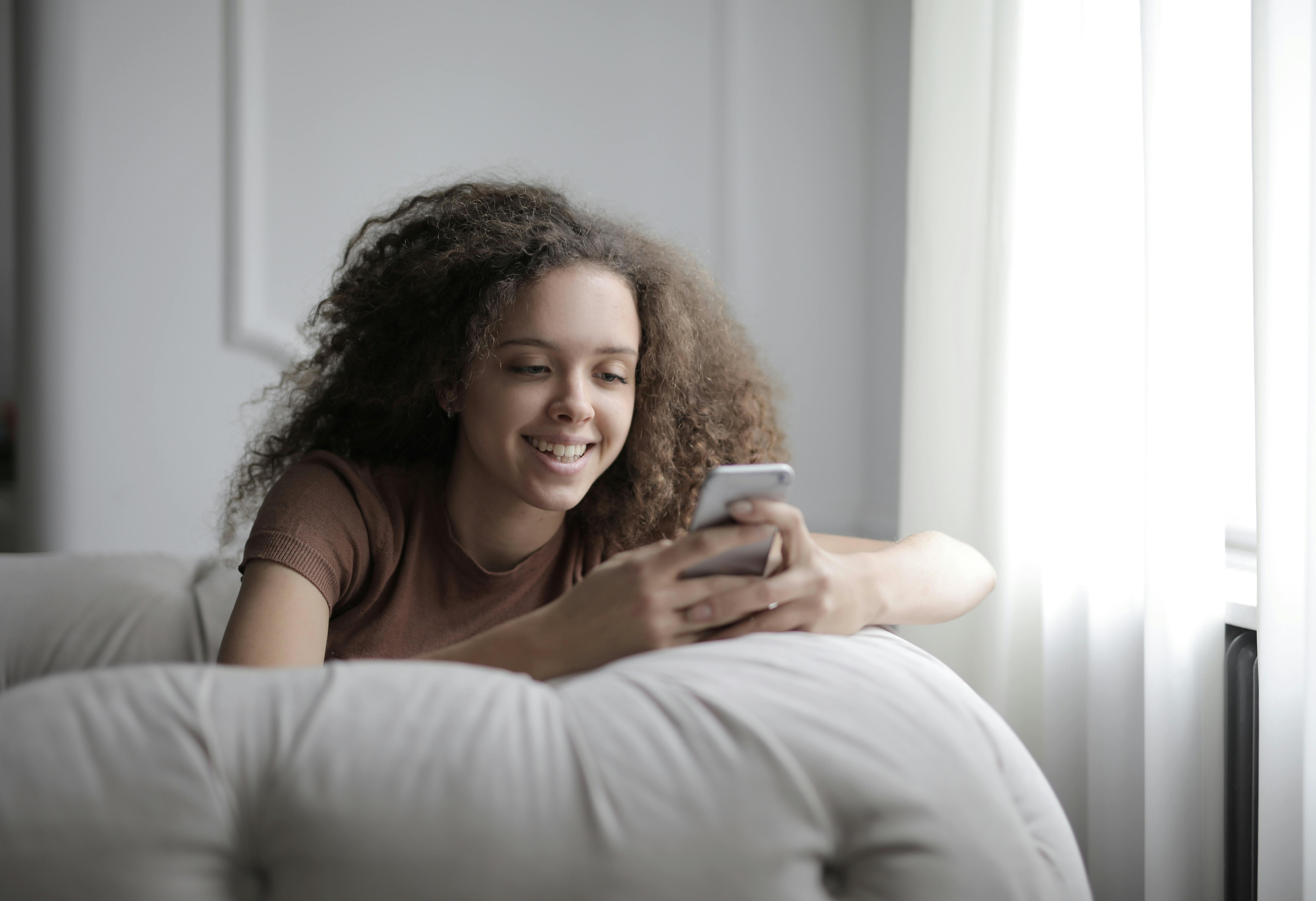 Une fille heureuse sur son téléphone | Source : Pexels