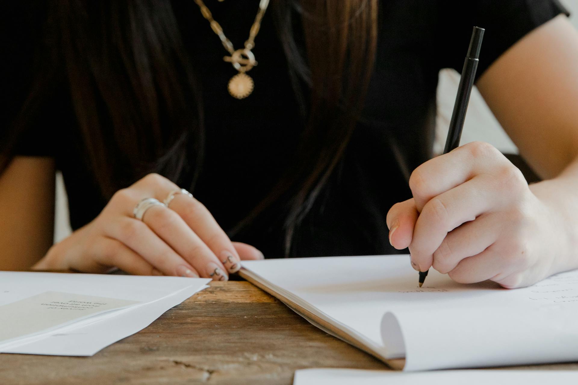 Une femme qui écrit sur du papier | Source : Pexels