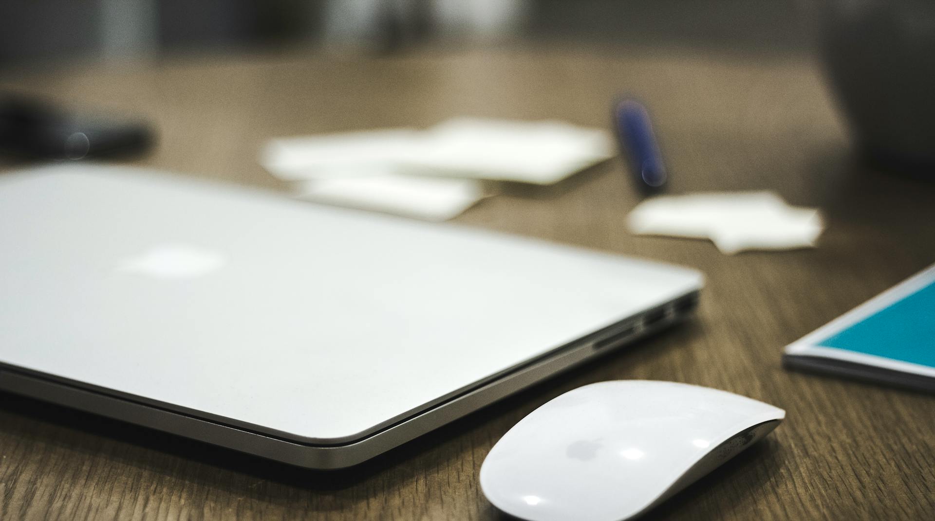 Un ordinateur portable et une souris sans fil sur la table | Source : Pexels