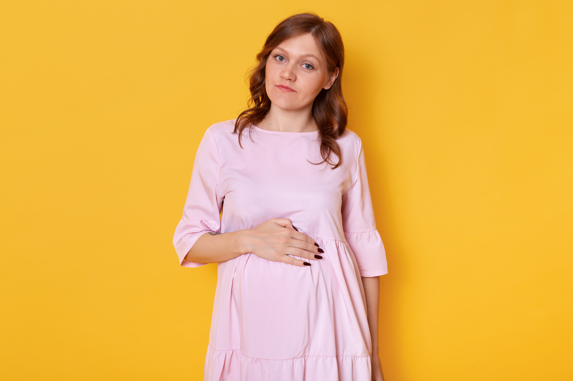 Une femme enceinte tenant son ventre rond | Source : Freepik