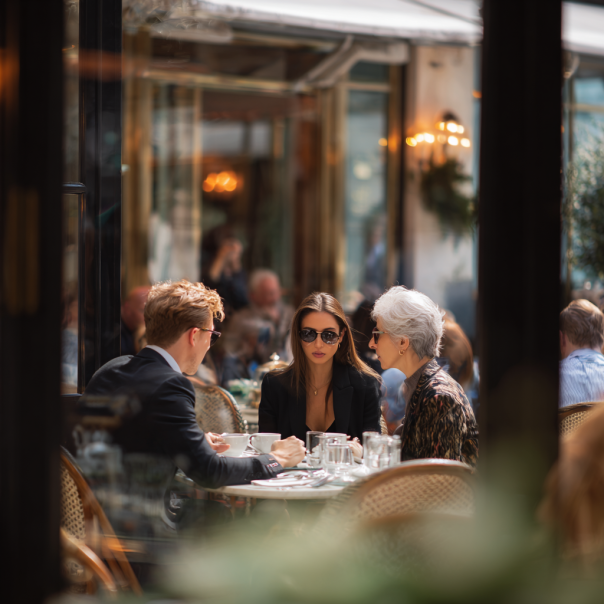 Un fils, sa fiancée et sa mère prenant un café | Source : Midjourney
