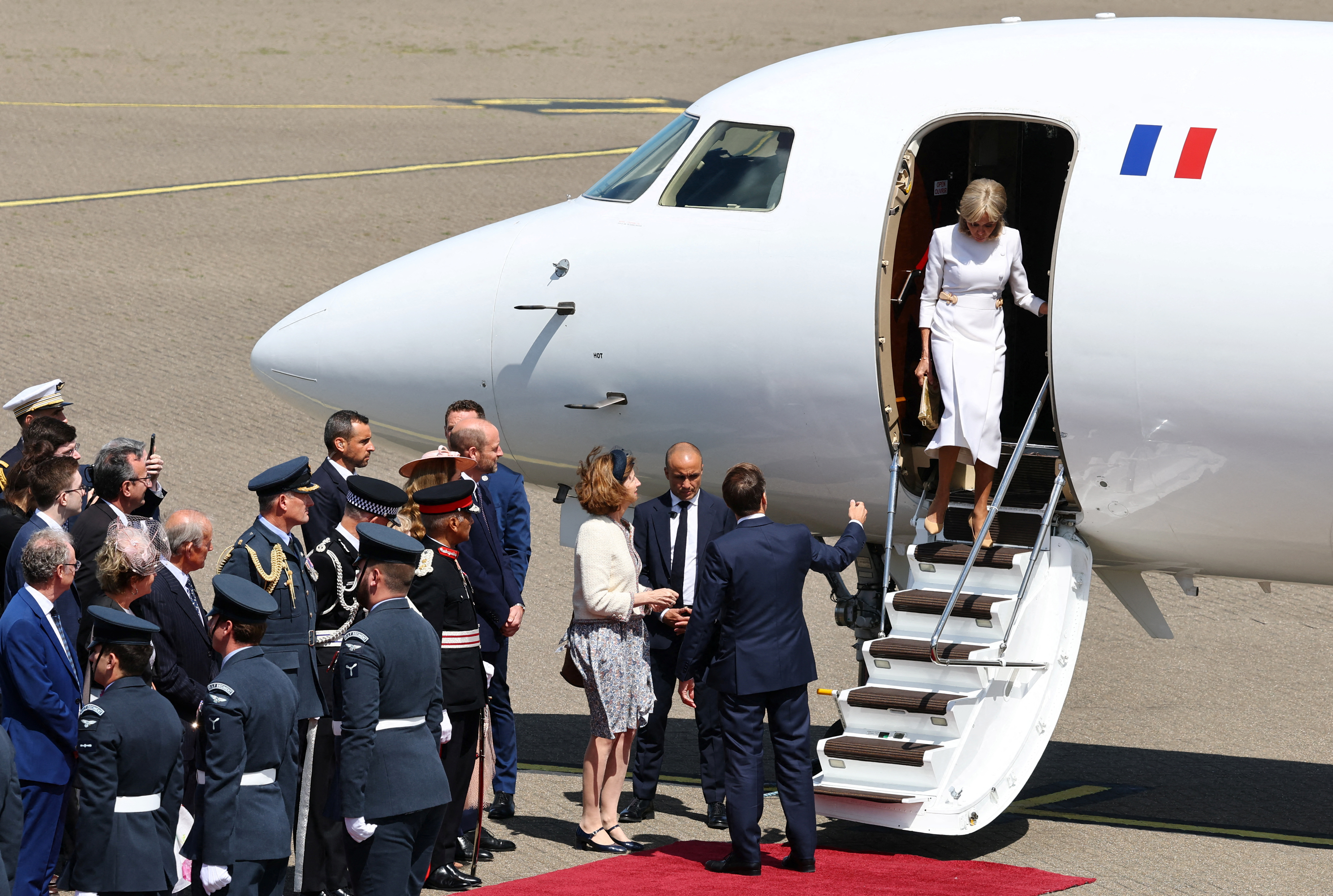 Brigitte Macron descendant les escaliers de l'avion alors qu'elle et son mari Emmanuel Macron arrivent au Royaume-Uni. | Source : Getty Images