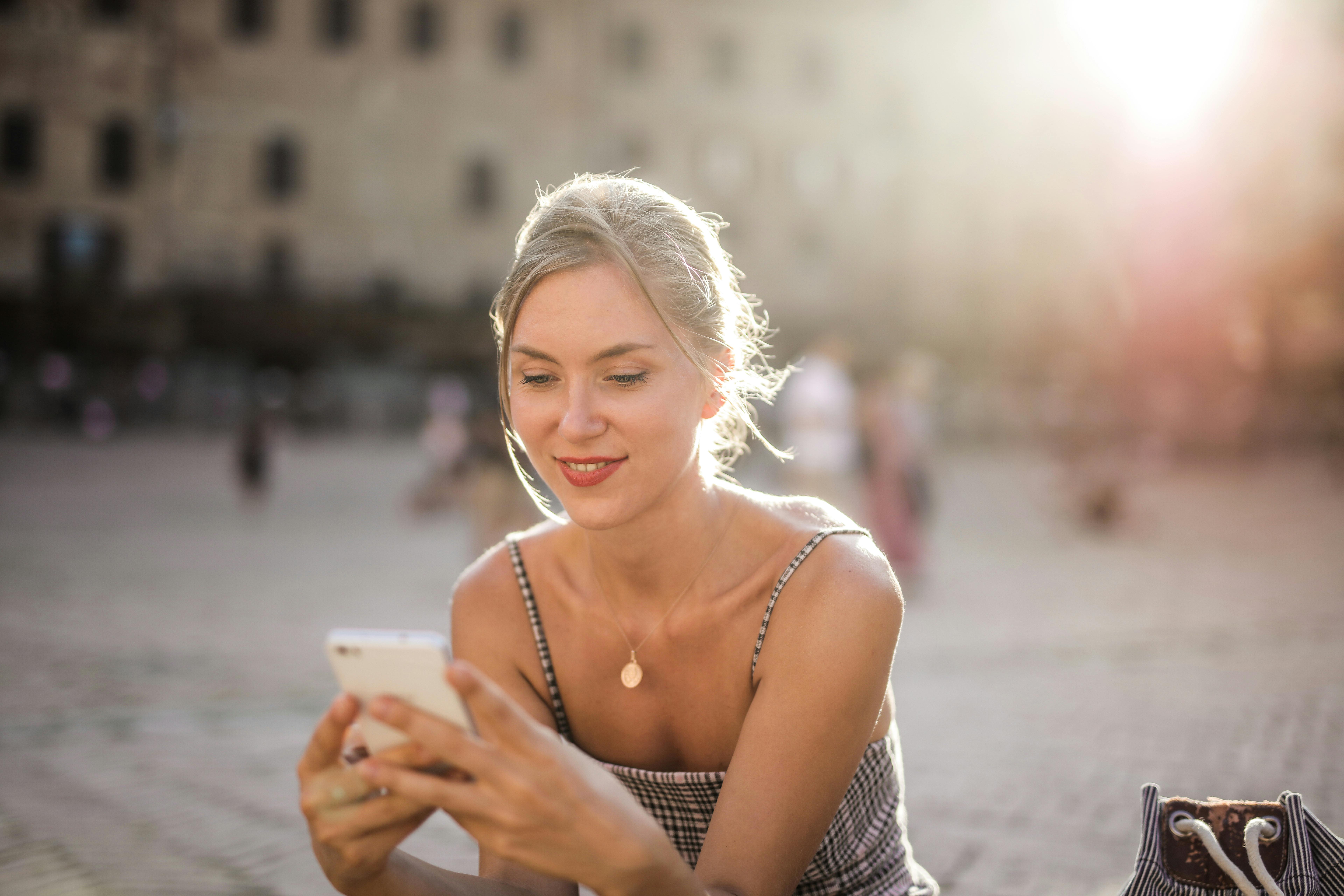 Une femme heureuse qui utilise son téléphone | Source : Pexels