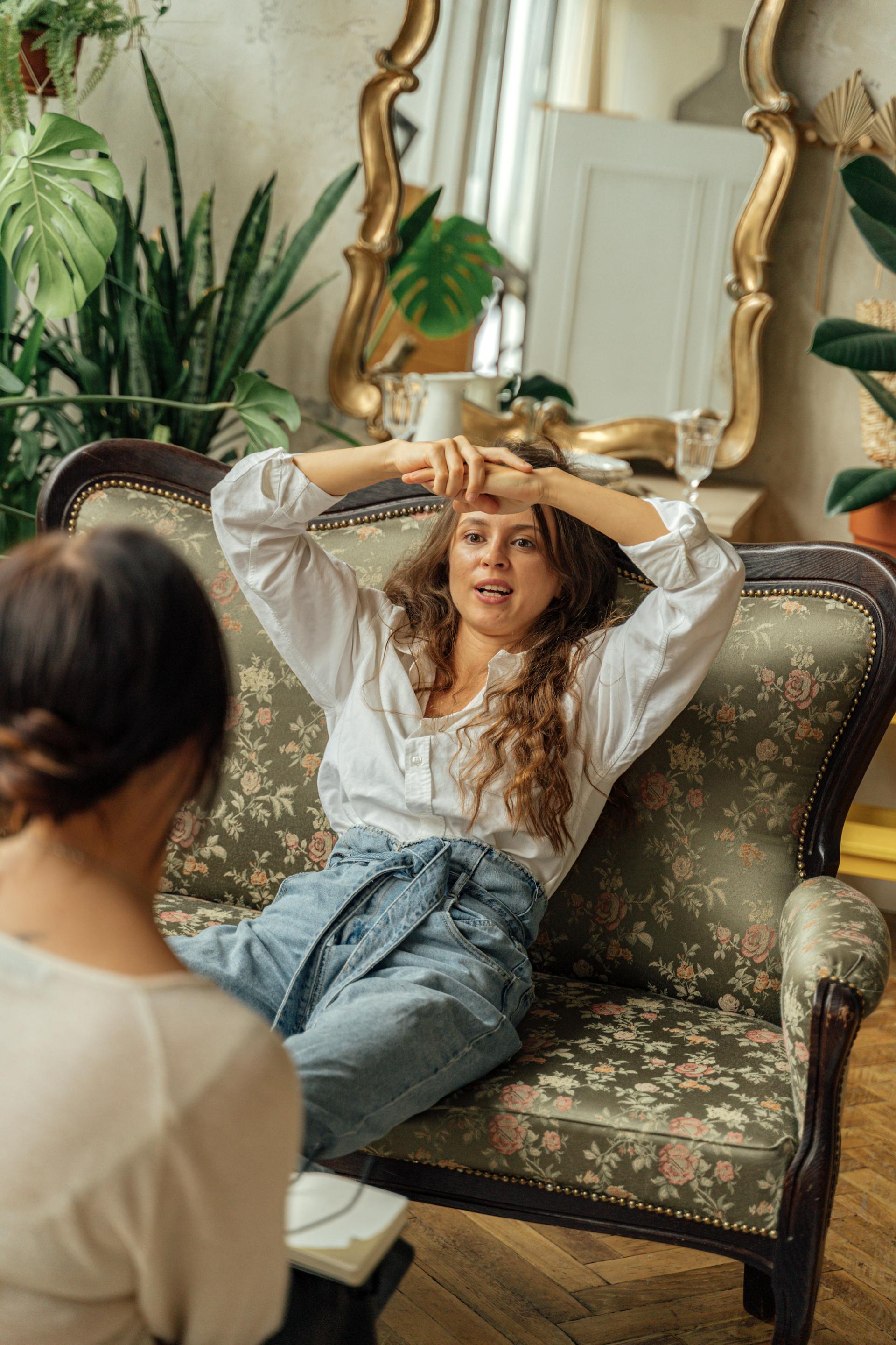 Une femme assise sur un canapé et parlant à son amie | Source : Pexels