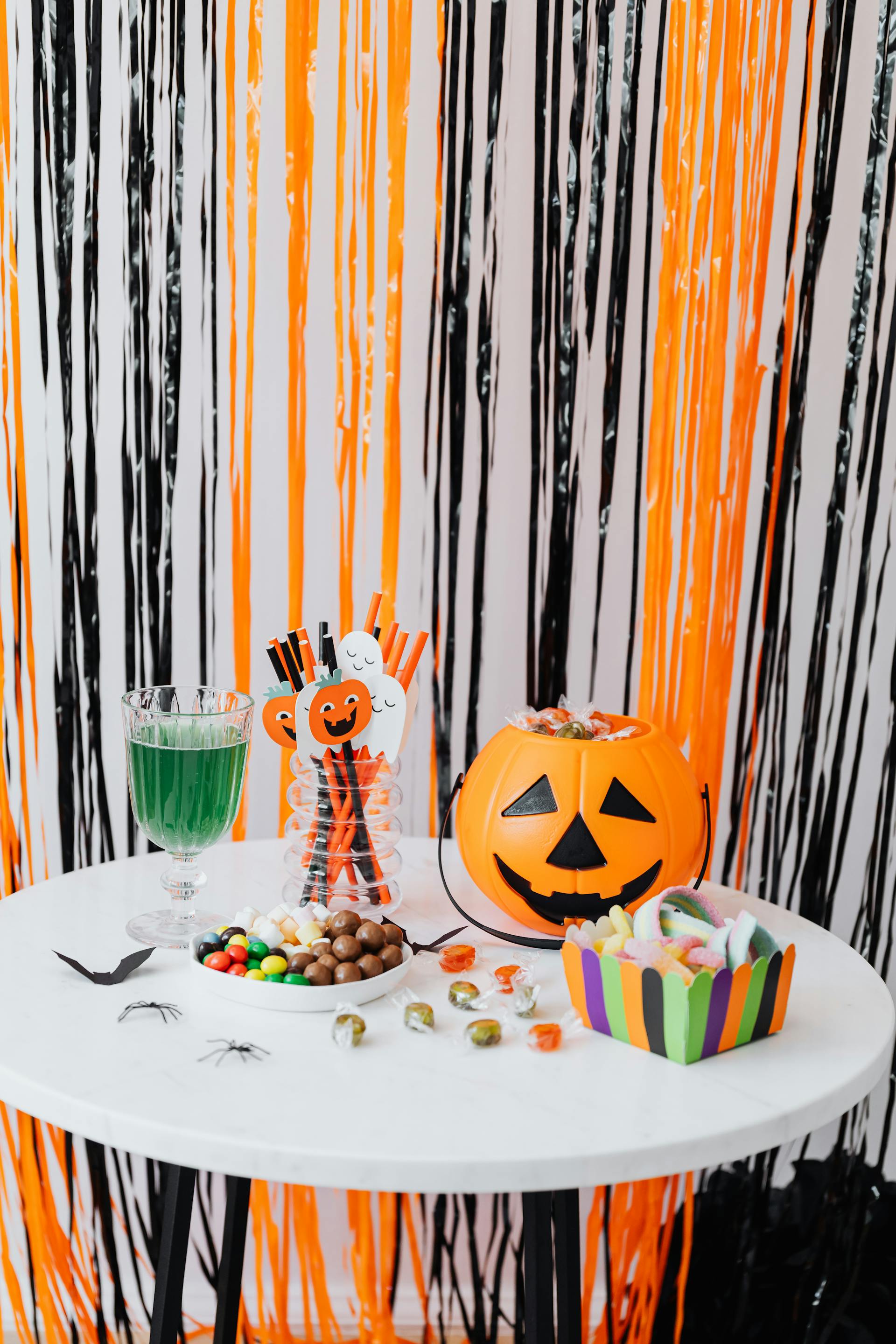Jack o' lantern avec des bonbons sur une table | Source : Pexels