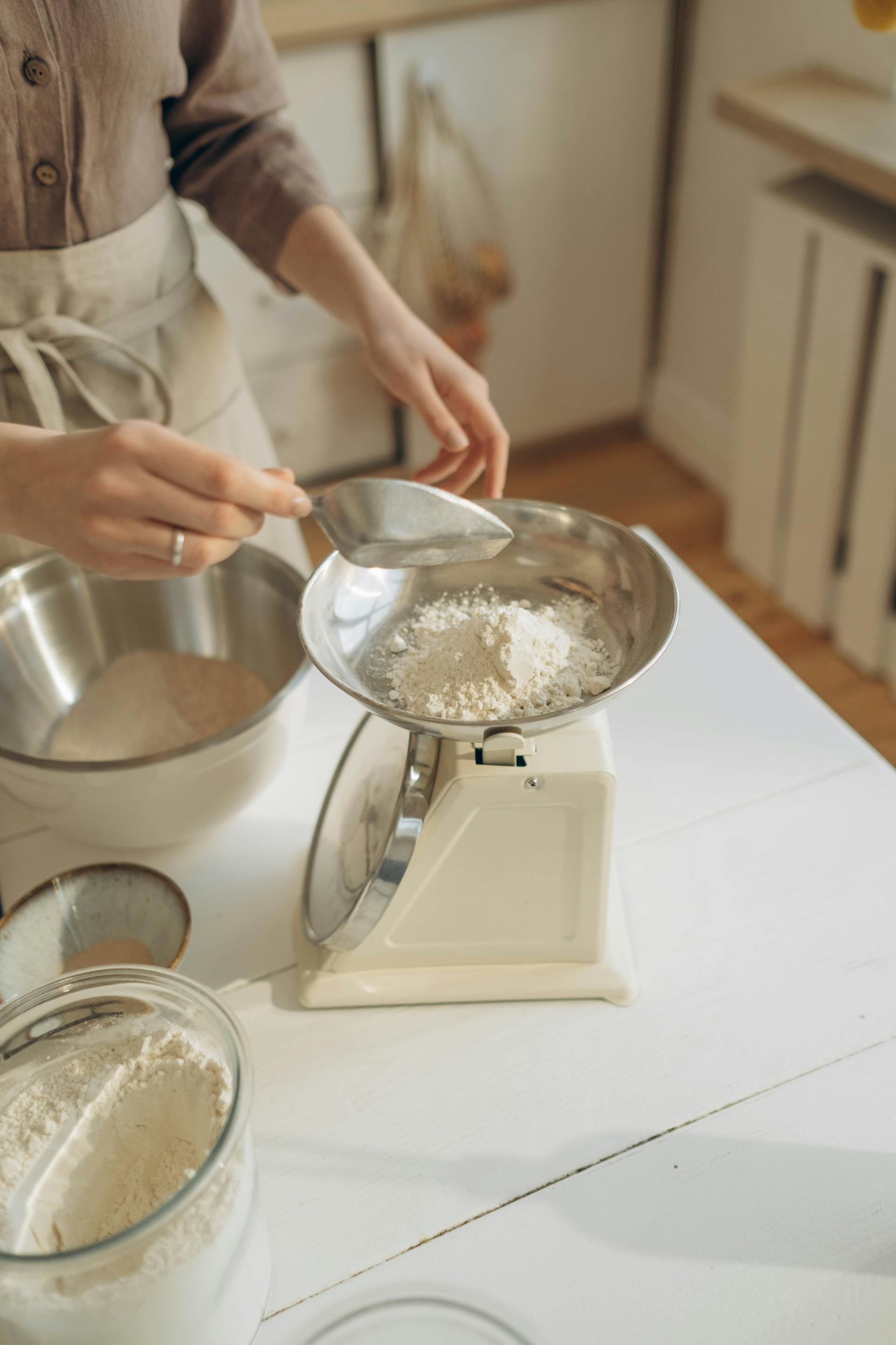 Une femme mettant de la farine sur une balance | Source : Pexels
