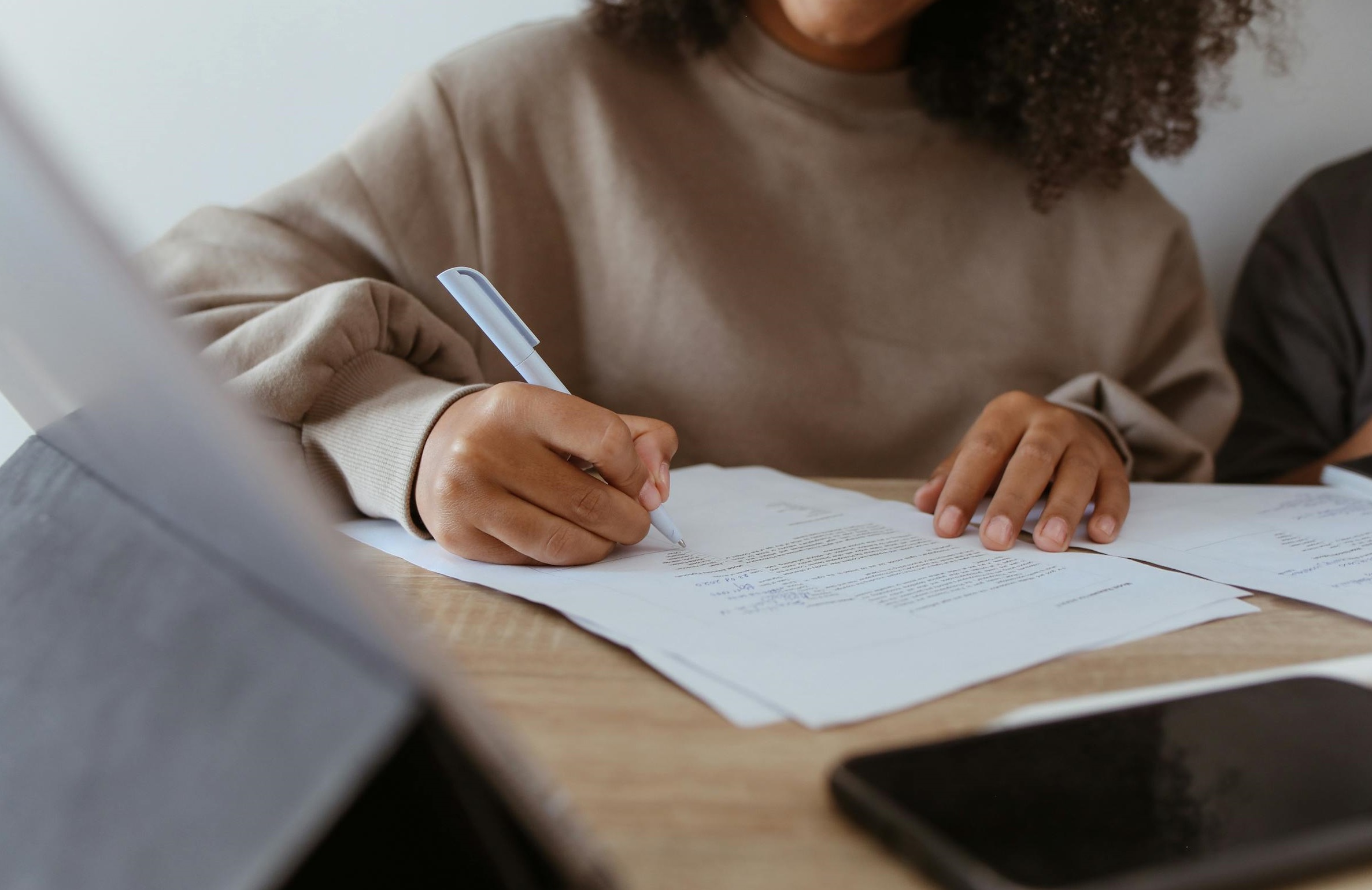 Une femme signant des documents administratifs | Source : Pexels