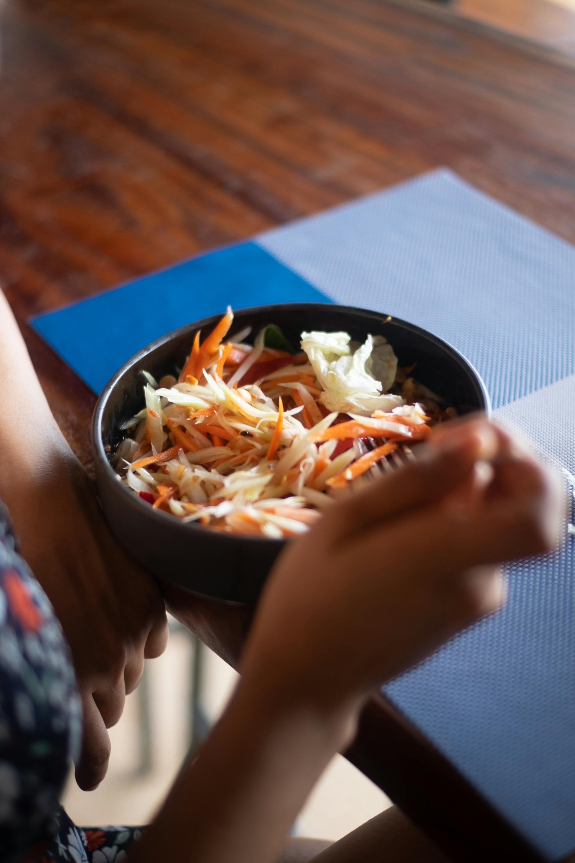 Gros plan d'une personne mangeant une salade dans un restaurant | Source : Pexels