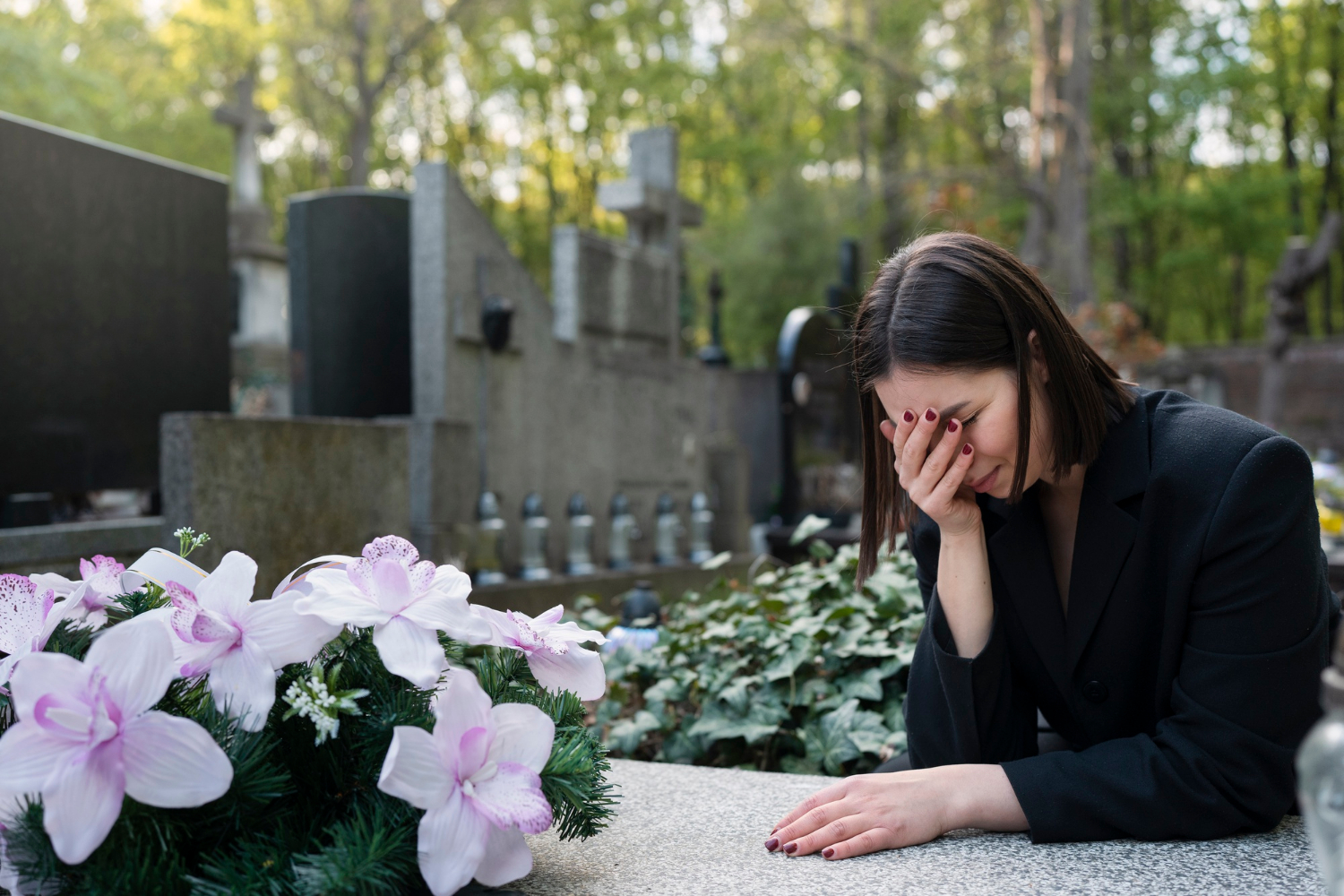 Une femme devant une tombe dans un cimetière | Source : Freepik