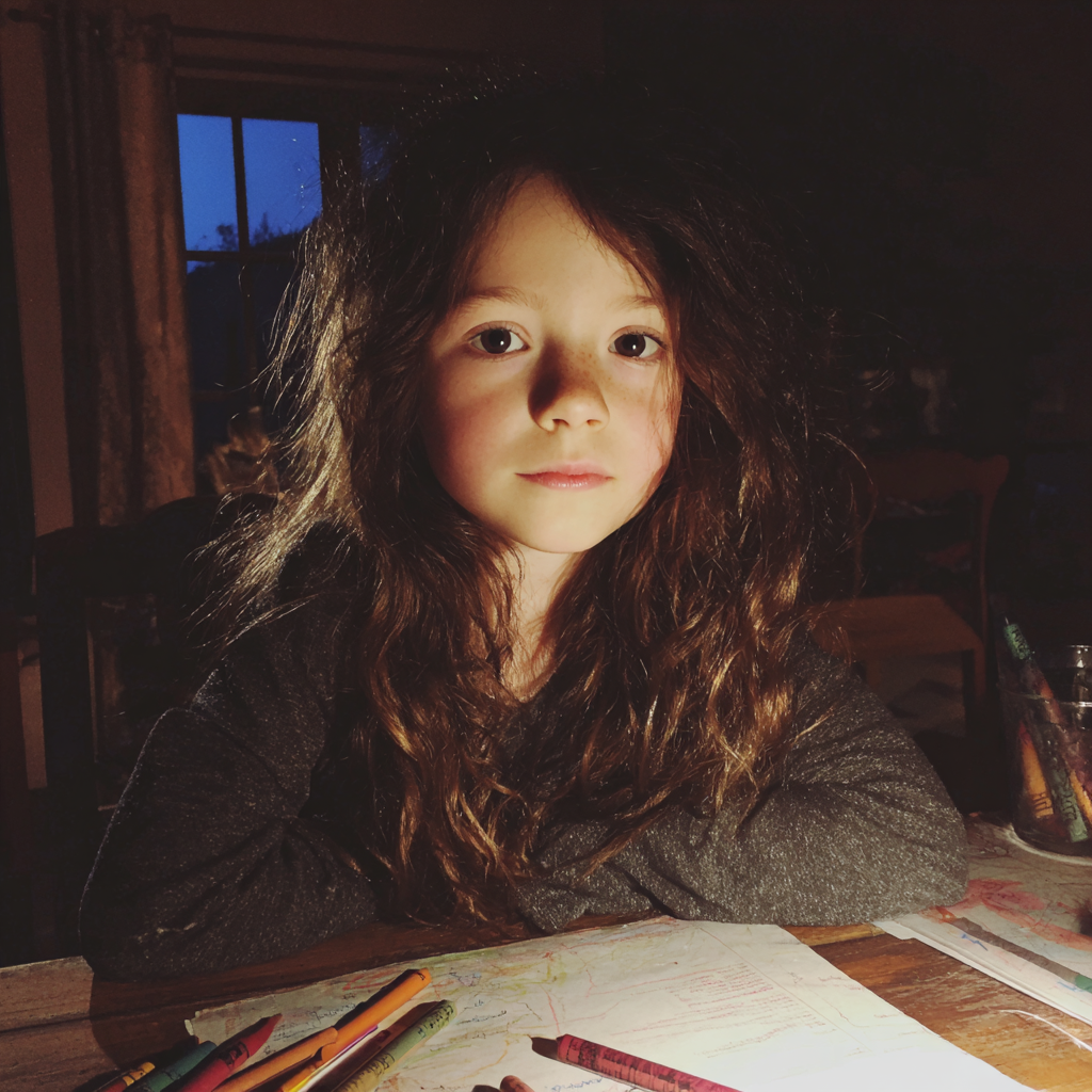 Une petite fille assise à une table à manger | Source : Midjourney