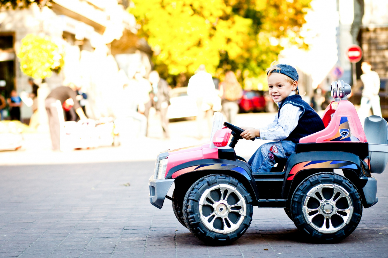 Un petit garçon heureux chevauchant sa voiture jouet | Source : Freepik