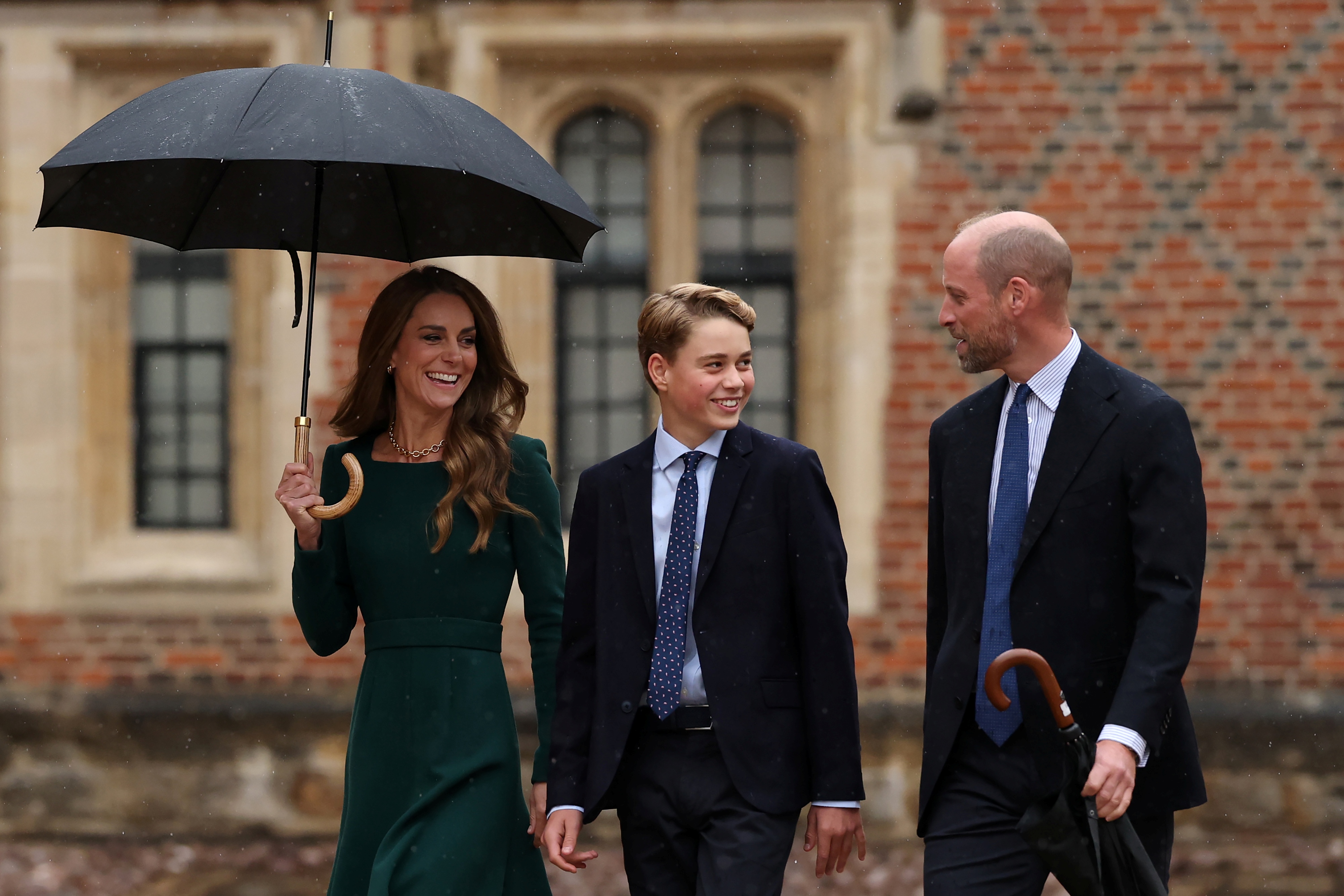 George s'est tourné vers William pendant un moment de détente, tandis que Catherine marchait à leurs côtés sous un parapluie. Cette arrivée en famille montrait les parents accompagnant leur fils aîné vers la prochaine étape de son parcours scolaire.