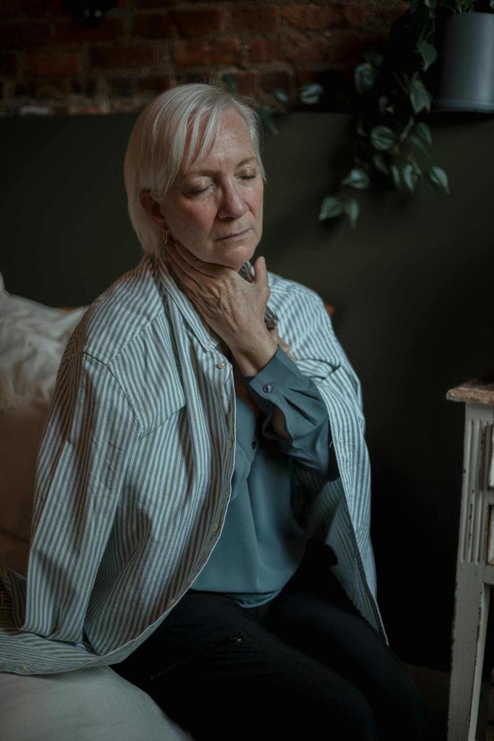 Une femme sérieuse assise sur son lit | Source : Pexels