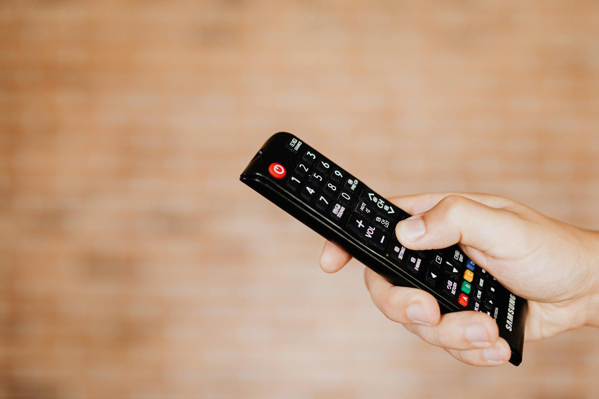 Un homme tenant une télécommande de télévision | Source : Pexels