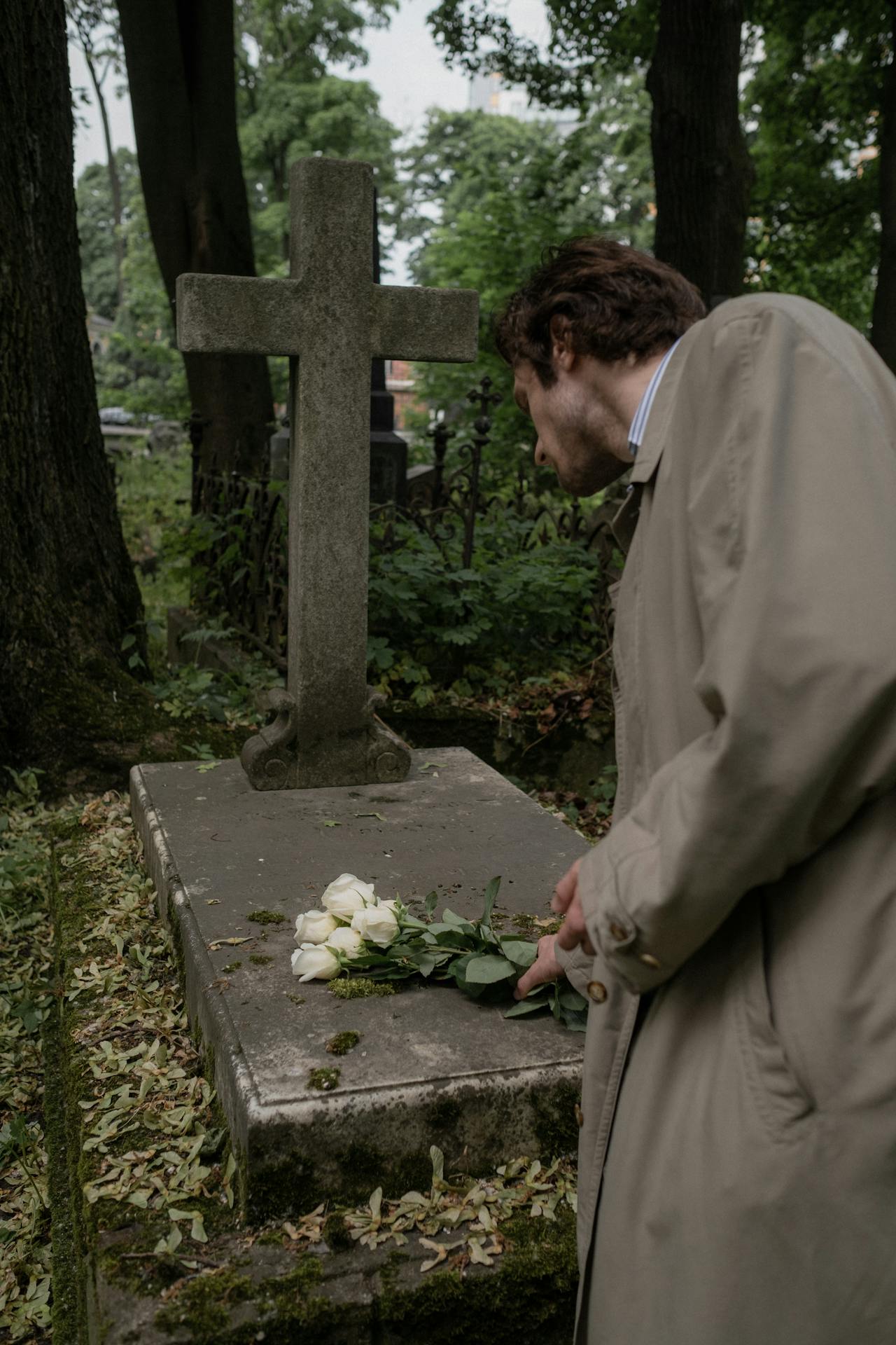 Un homme dépose des fleurs sur une tombe | Source : Pexels