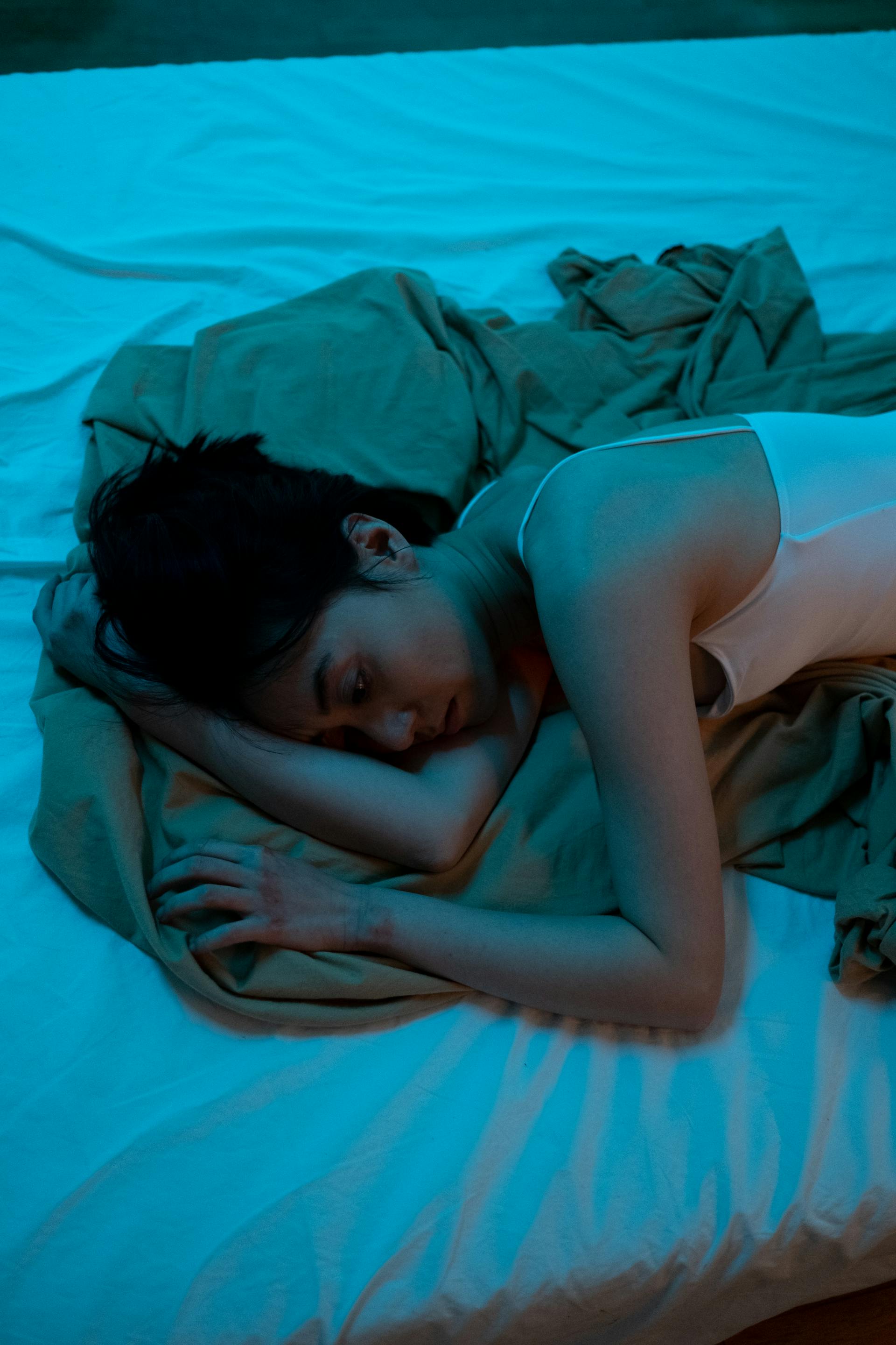 Une femme triste allongée sur un lit | Source : Pexels