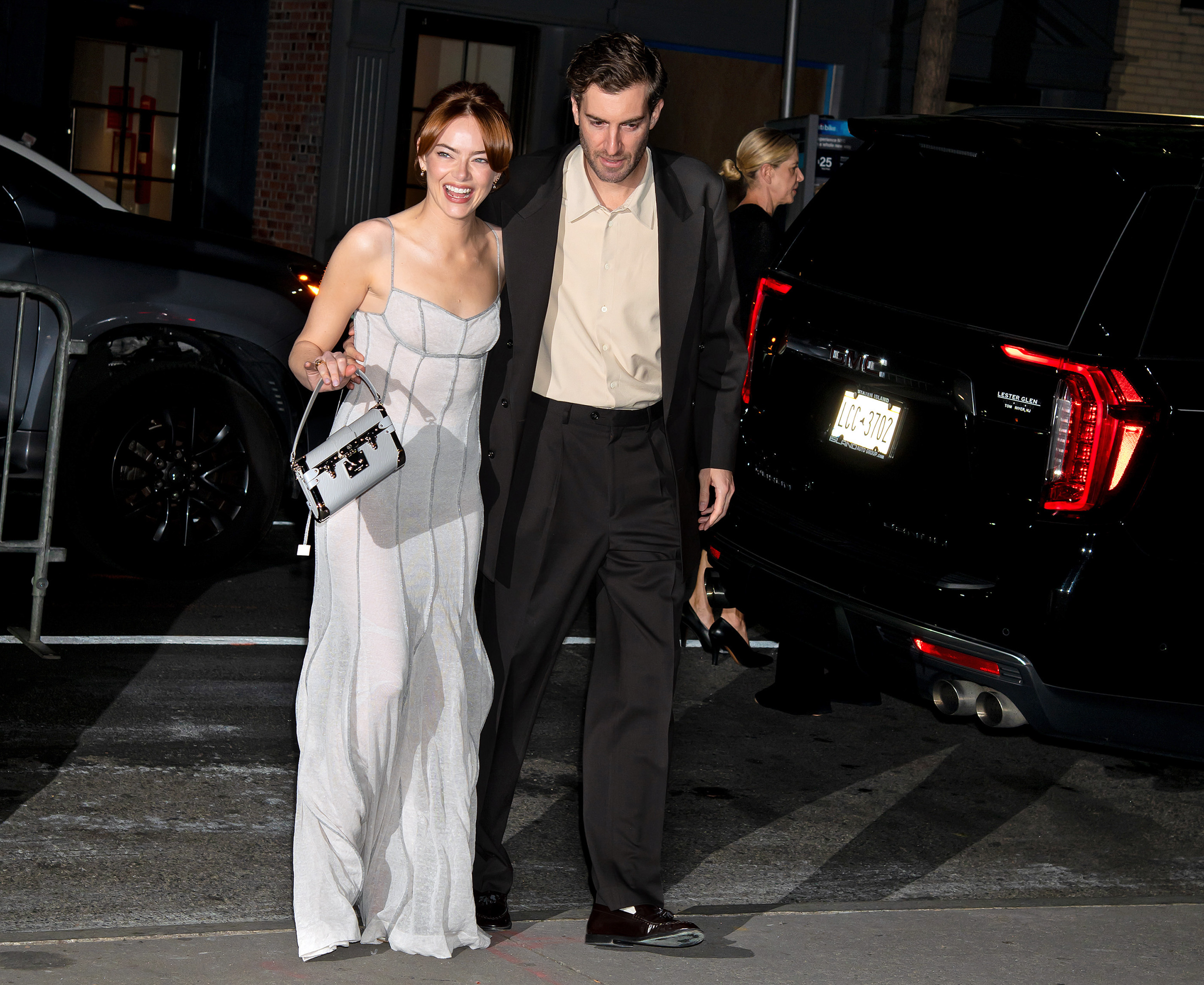 Main dans la main avec son mari Dave McCary, Emma Stone fait son entrée sur scène avec un sourire radieux, sa robe argentée fluide reflétant la sophistication naturelle de la soirée.