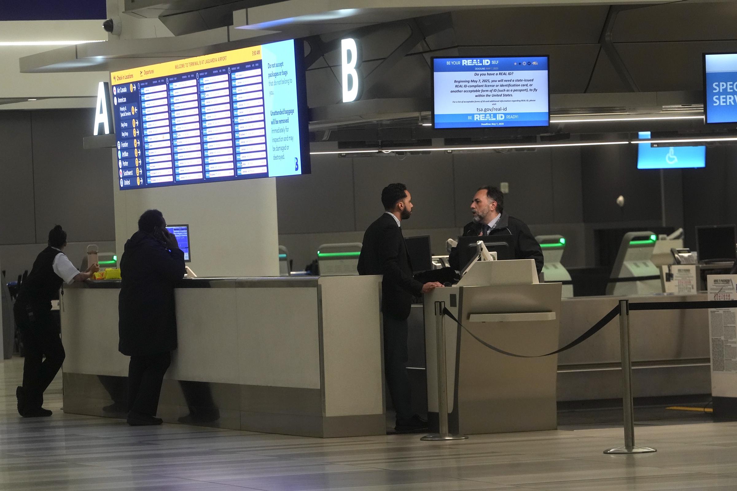 Des passagers s'adressent au personnel d'un comptoir d'assistance à l'aéroport LaGuardia après sa fermeture. | Source : Getty Images