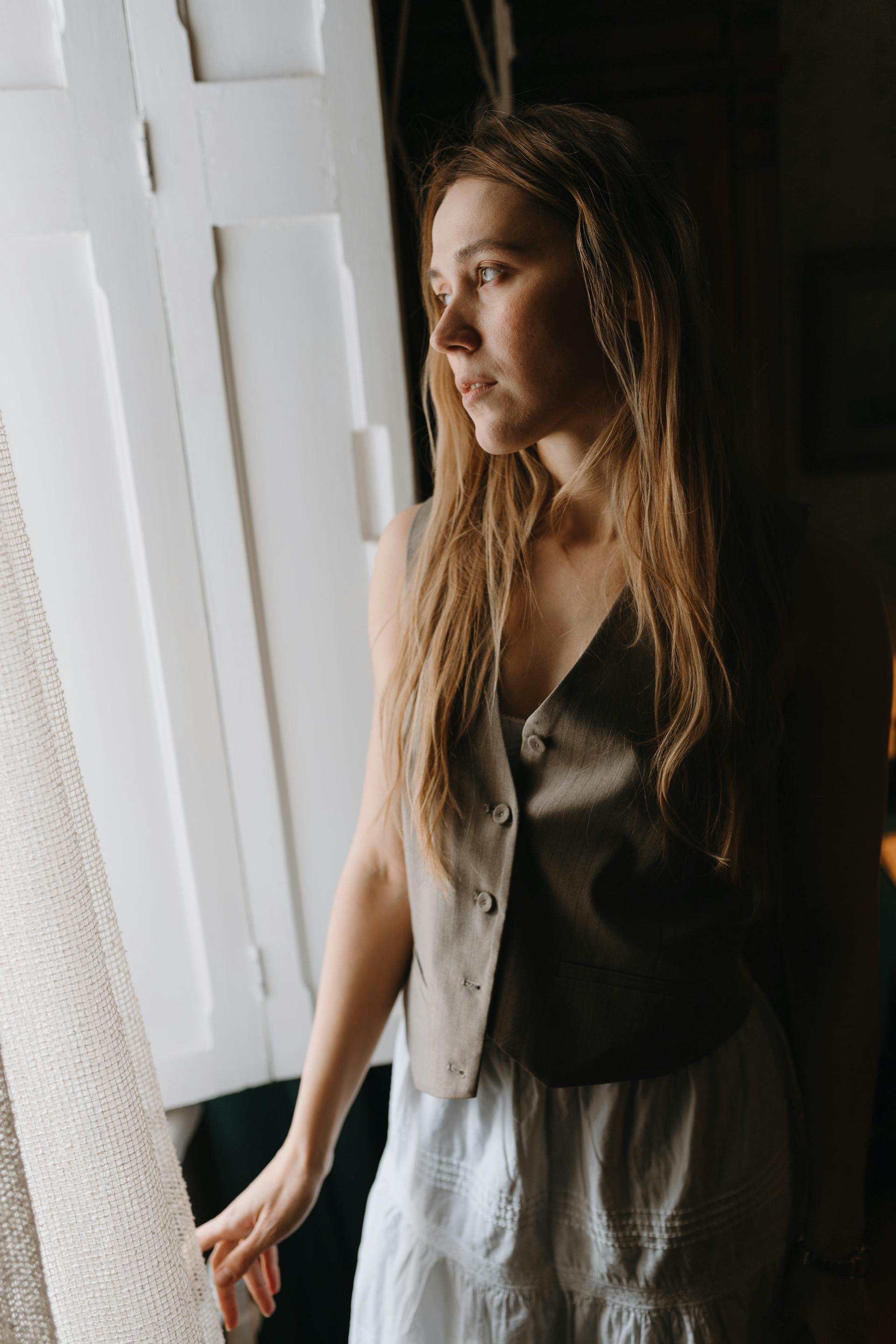 Une femme debout près de la fenêtre dans une chambre | Source : Pexels
