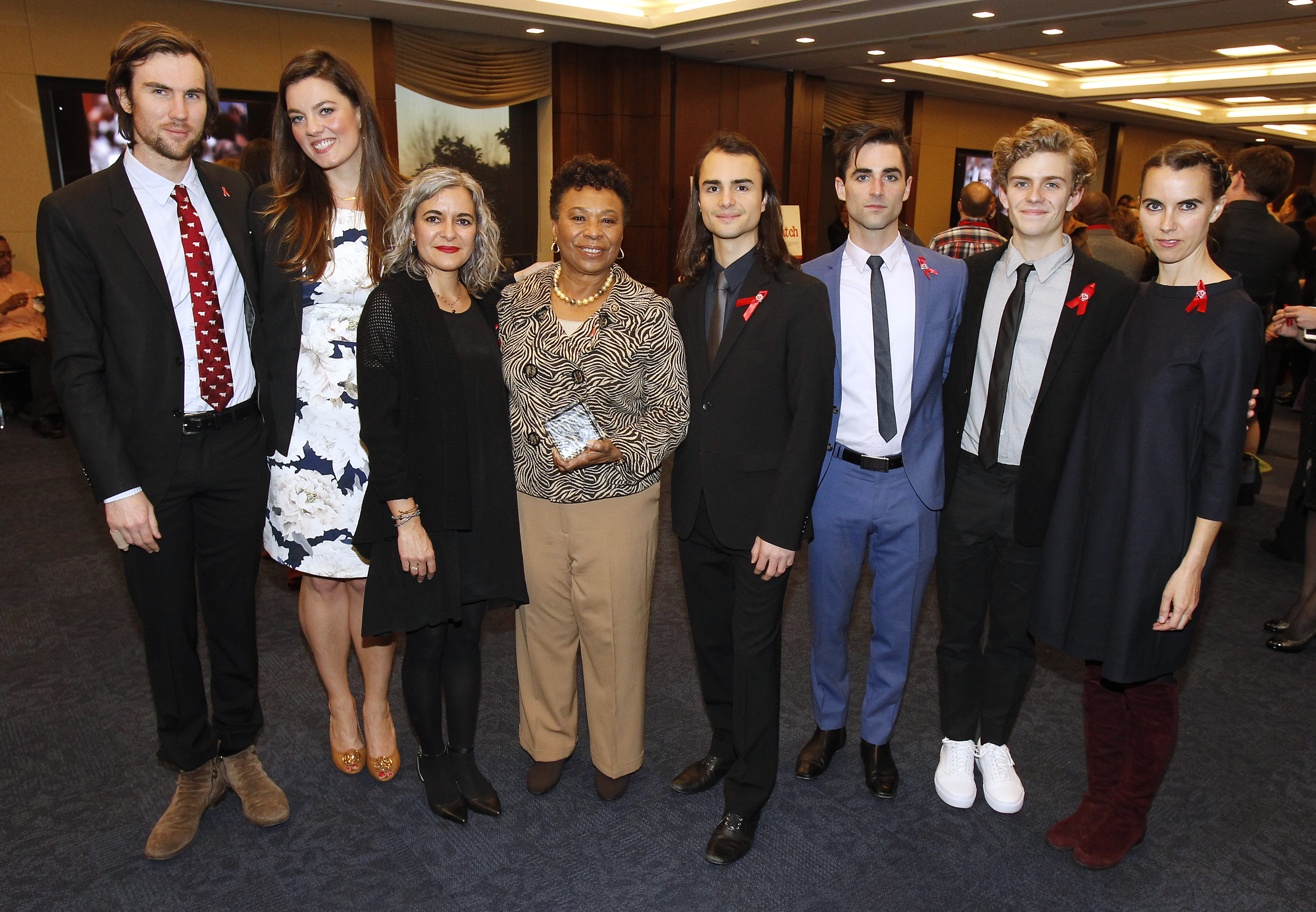 Barbara Lee (C) pose avec les proches d'Elizabeth Taylor (de gauche à droite) Tarquin Wilding, Eliza Carson, Laela Wilding, Rhys Tivey, Quinn Tivey, Finn McMurray et Naomi Wilding lors de la réception du prix du leadership positif d'AIDSWatch, le 29 février 2016, à Washington. | Source : Getty Images