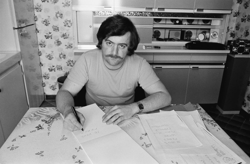 Bernard Laroche recopiant une lettre anonyme reçue par les parents de Gregory Villemin assasiné en 1984 | Source : Getty Images