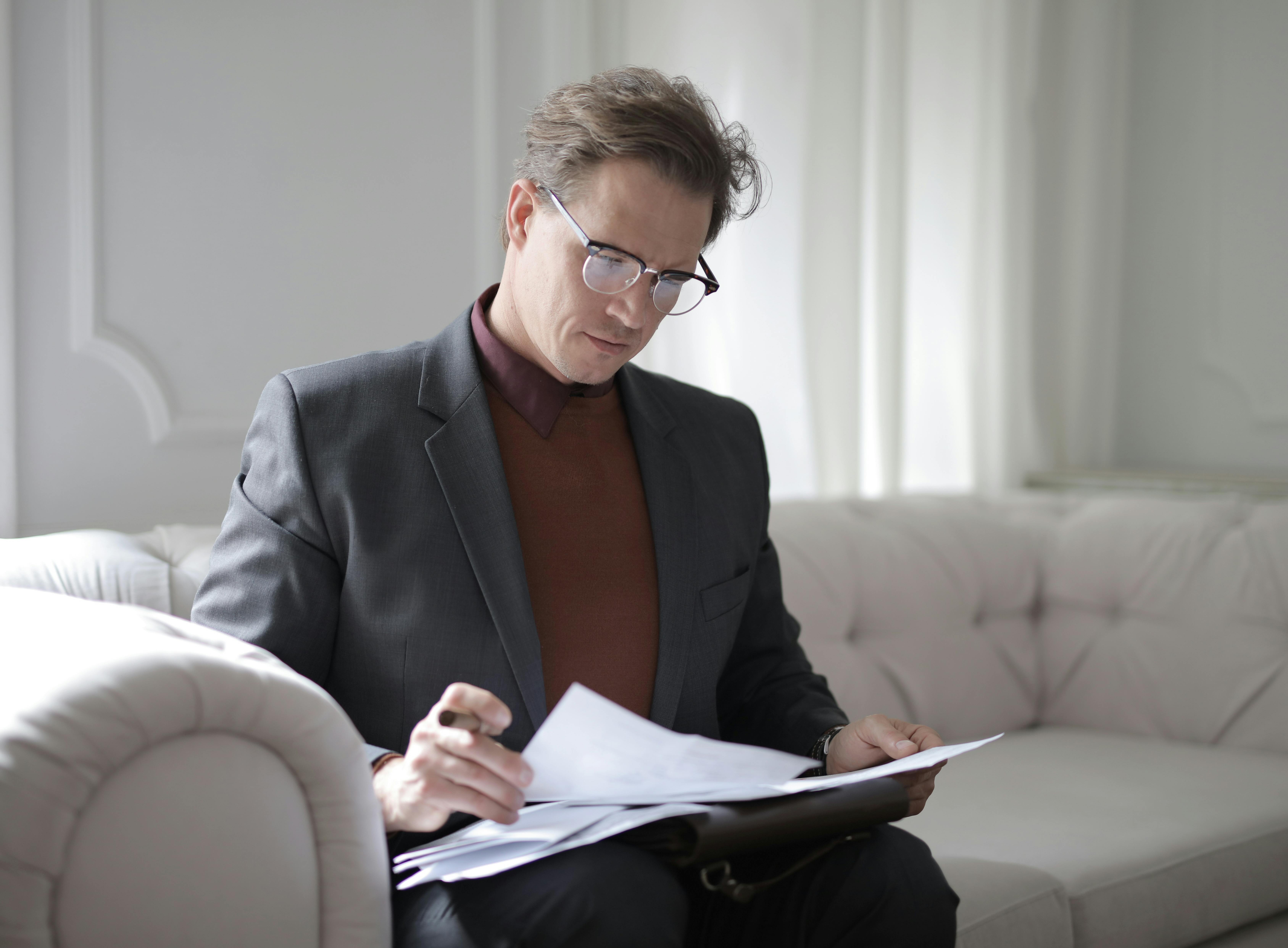 Un homme qui consulte de la paperasse | Source : Pexels