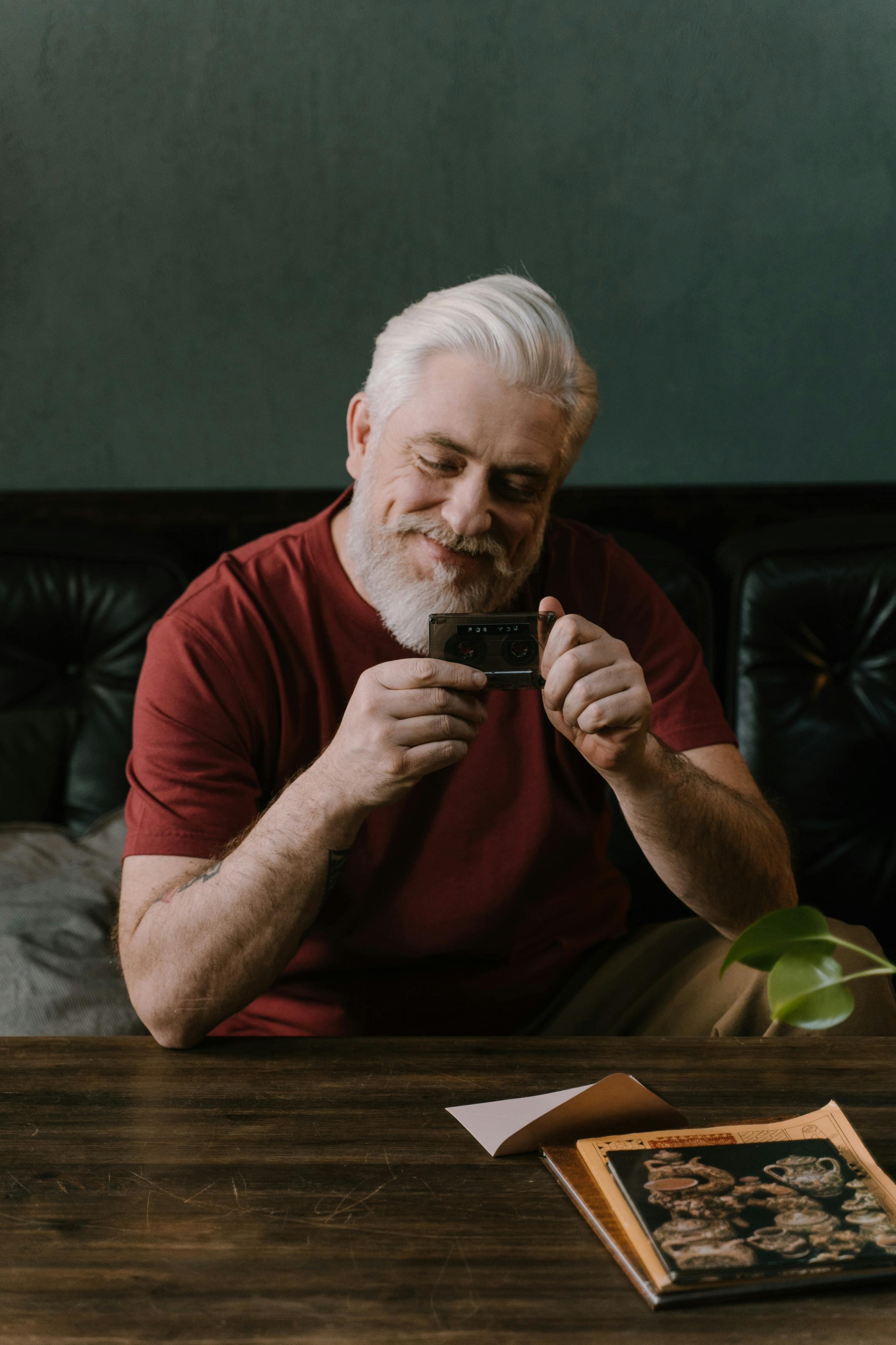 Un homme âgé souriant assis à une table | Source : Pexels